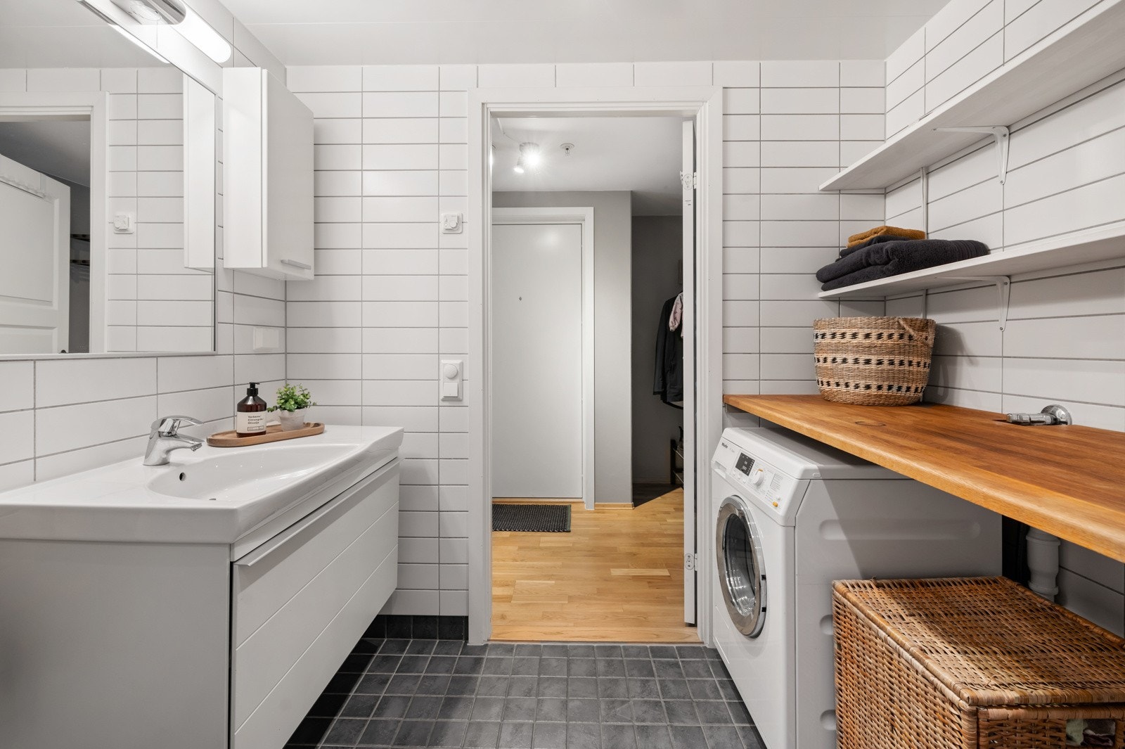 Baderommet er utstyrt med vegghengt klosett med innebygget sisterne, samt servant med praktisk underskuff for oppbevaring, samt opplegg for vaskemaskin Galleribilde