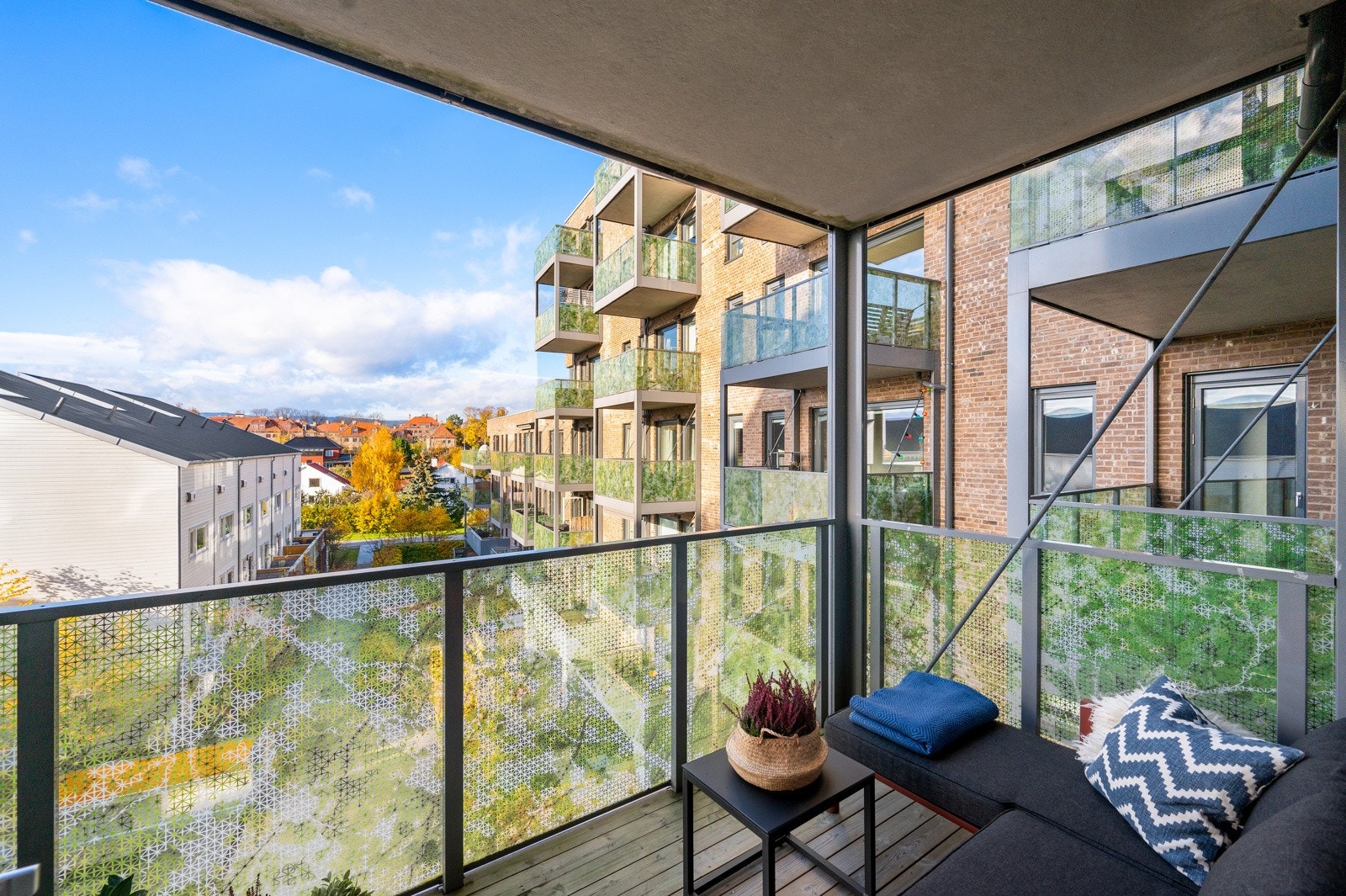 Balkongen er delvis overbygd og pent innredet med plass til sittegruppe og blomsterkrukker Galleribilde