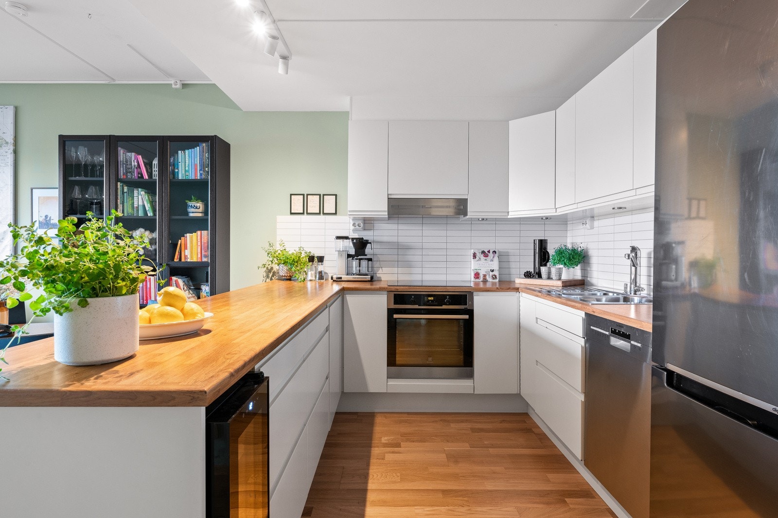 Kjøkkenet har i tillegg en innfelt vinskap i kjøkkenøyen, og god plass til kjøleskap/fryseskap i full høyde Galleribilde