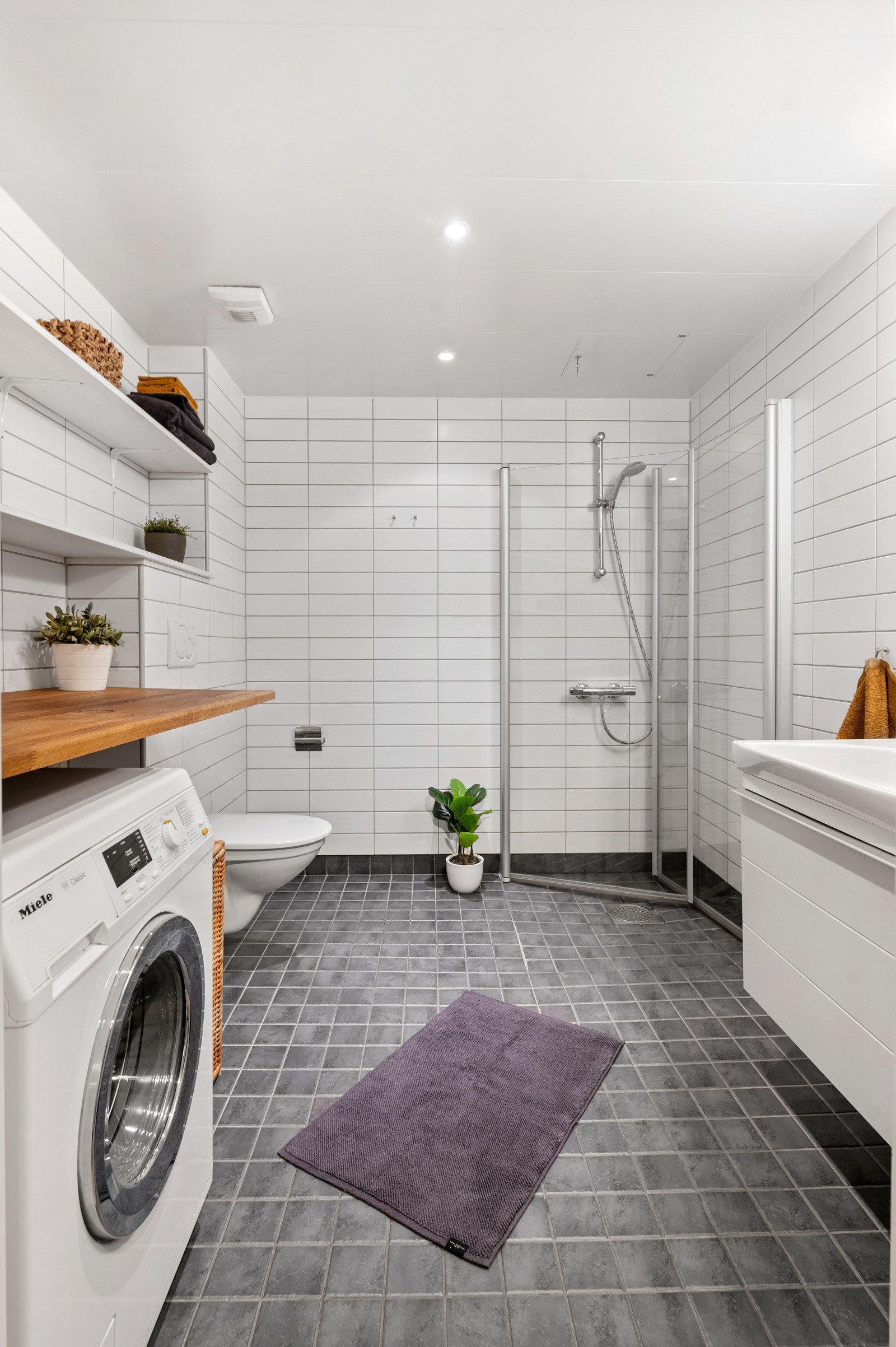 Dusjen er plassert rett på gulv og har elegante dusjdører i herdet glass som kan svinges inn for bedre plassutnyttelse Galleribilde