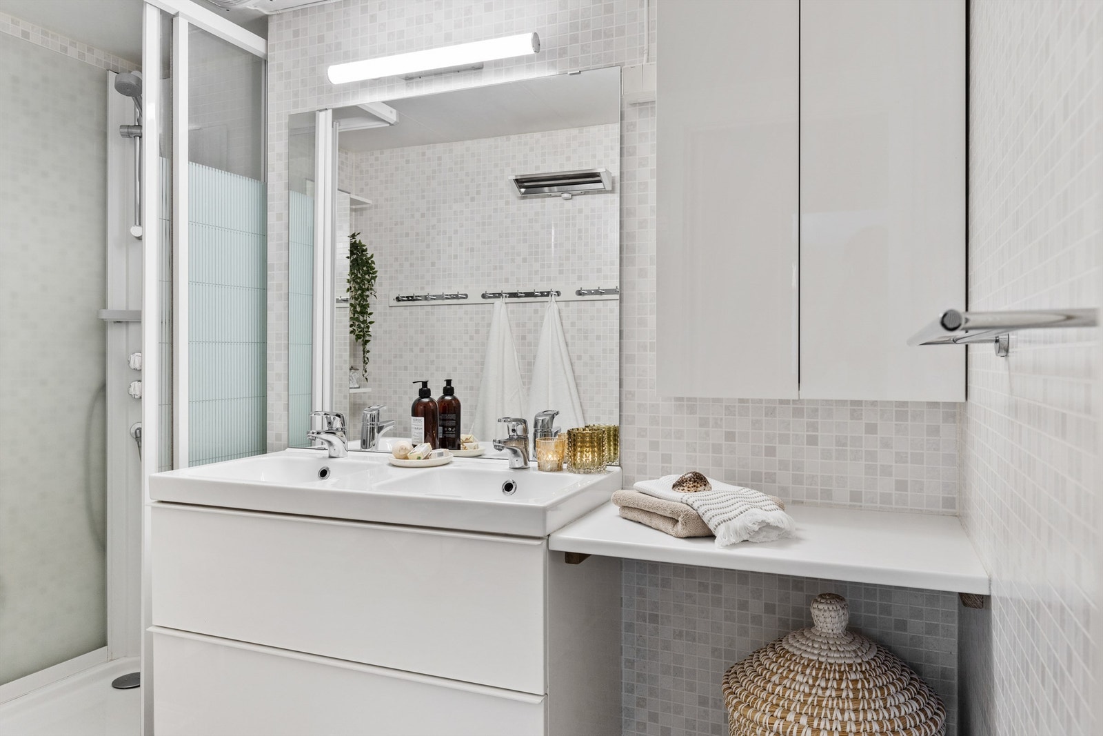 Badet i 2. etasje er innredet med dusjkabinett og dobbel servant på innredning. Det er også godt med oppbevaringsplass i skuffer og skap. Galleribilde