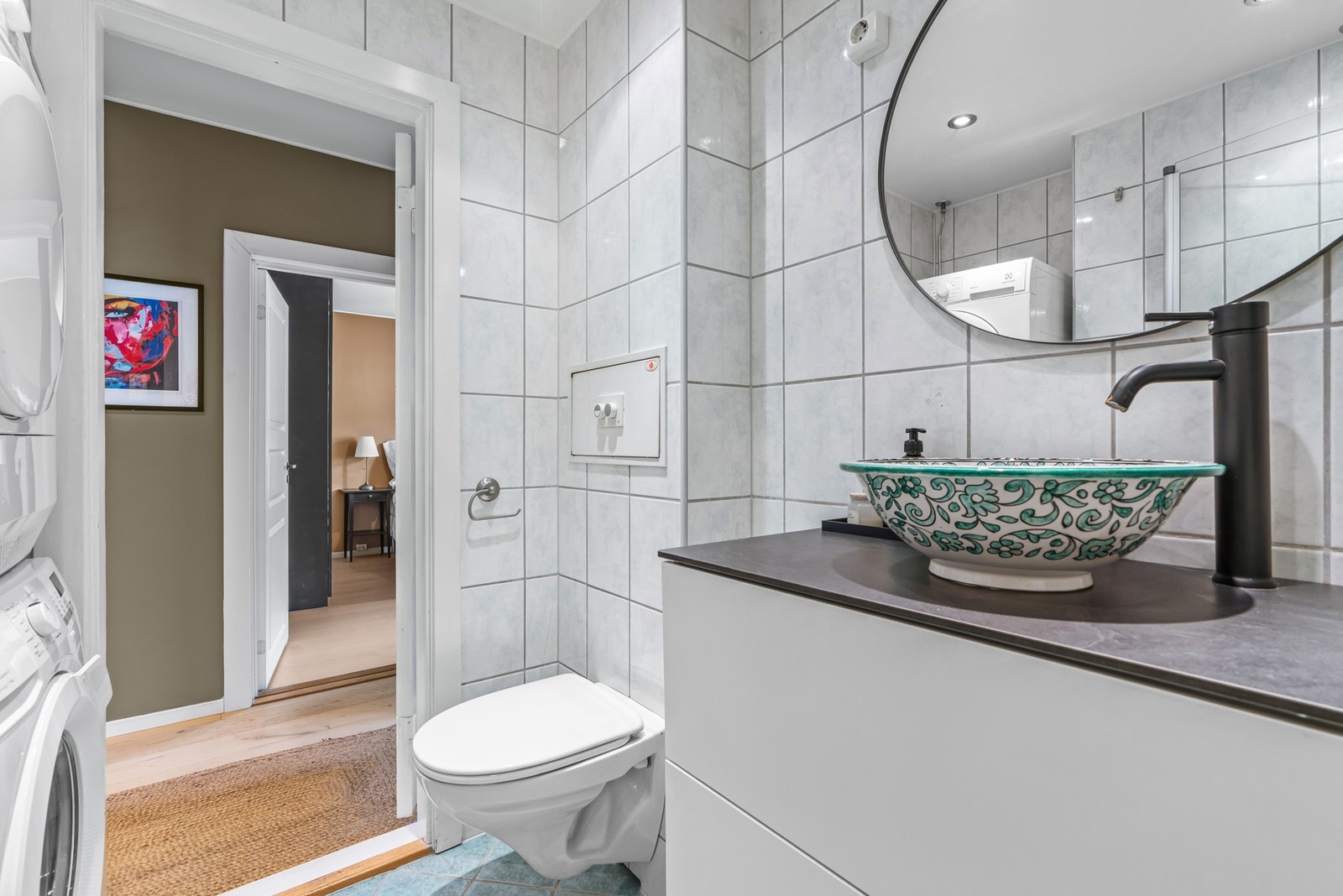 Innredningen fra 2022 består av en dekorert bollservant på pen, hvit skuffeseksjon, rundt speil med belysning. Rommet har ellers gulvvarme og downlights i himling. Galleribilde