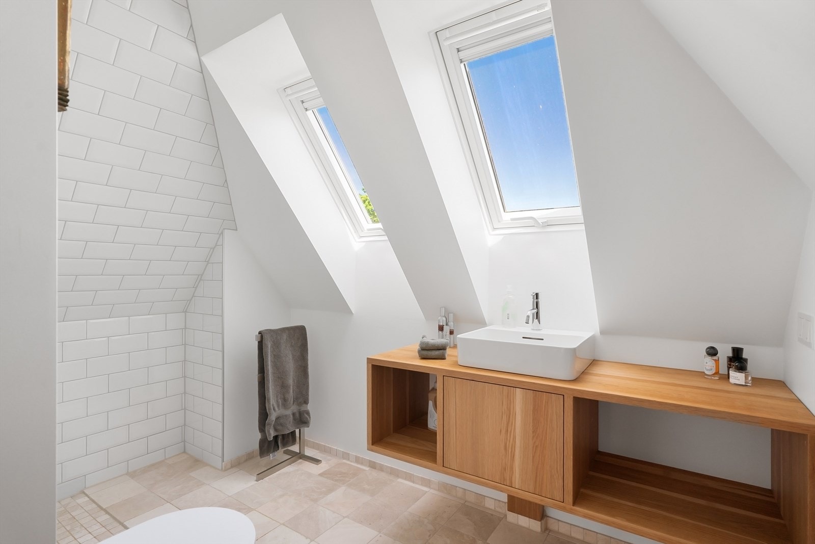 Bad på loftet med servant med innredning, toalett og dusj i hjørnet. Galleribilde