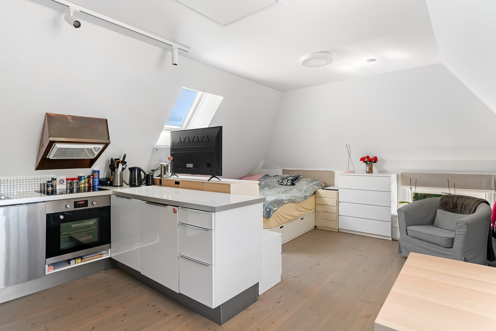 Hybel med kjøkken, bad og stue med åpen kjøkkenløsning. Kjøkkenet har Integrerte hvitevarer som stekeovn, komfyr med keramisk topp og oppvaskmaskin Galleribilde