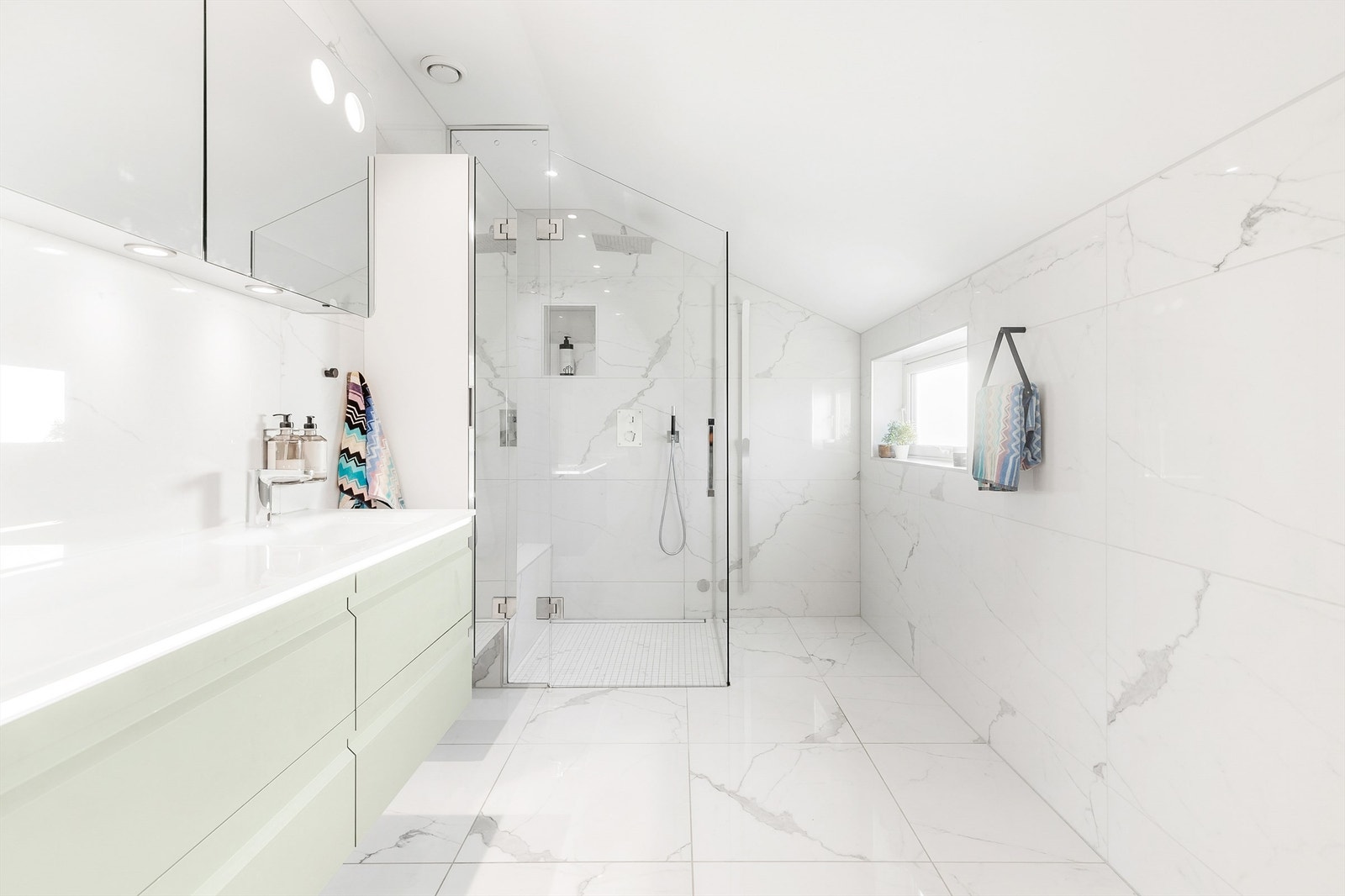 Dusj i hjørne og dusjvegger av glass Dusjbatteri, armatur og regnfallsdusj integrert i vegg. Galleribilde