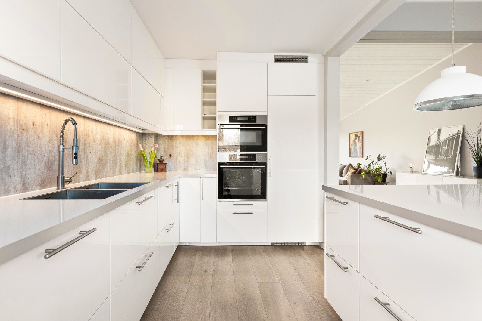 Kjøkkeninnredning med svært romslig innredning - god skap- og benkplass. Innredningen er fra Ikea (2017/ montert av Montera AS) og har slette, takhøye fronter i hvit, glatt utførelse og med moderne håndtak i stålfarge. Matchende hvit benkeplate av laminat Galleribilde