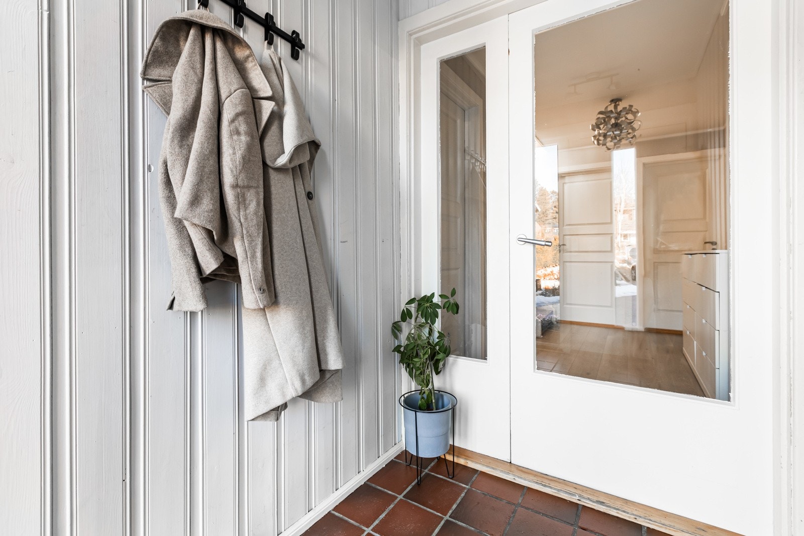 Praktisk vindfang med flislagt gulv med varmekabler. Ny utgangsdør fra 2018 og mellomdør som holder varmen inne selv om ytterdøren er åpen. Galleribilde