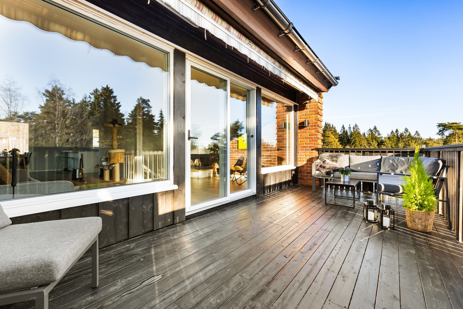 Utgang fra stue til veranda på 16 kvm. Bjelkelag med terrassebord og rekkverk av tre, pusset opp/nytt i 2020. Manuell markise. Galleribilde