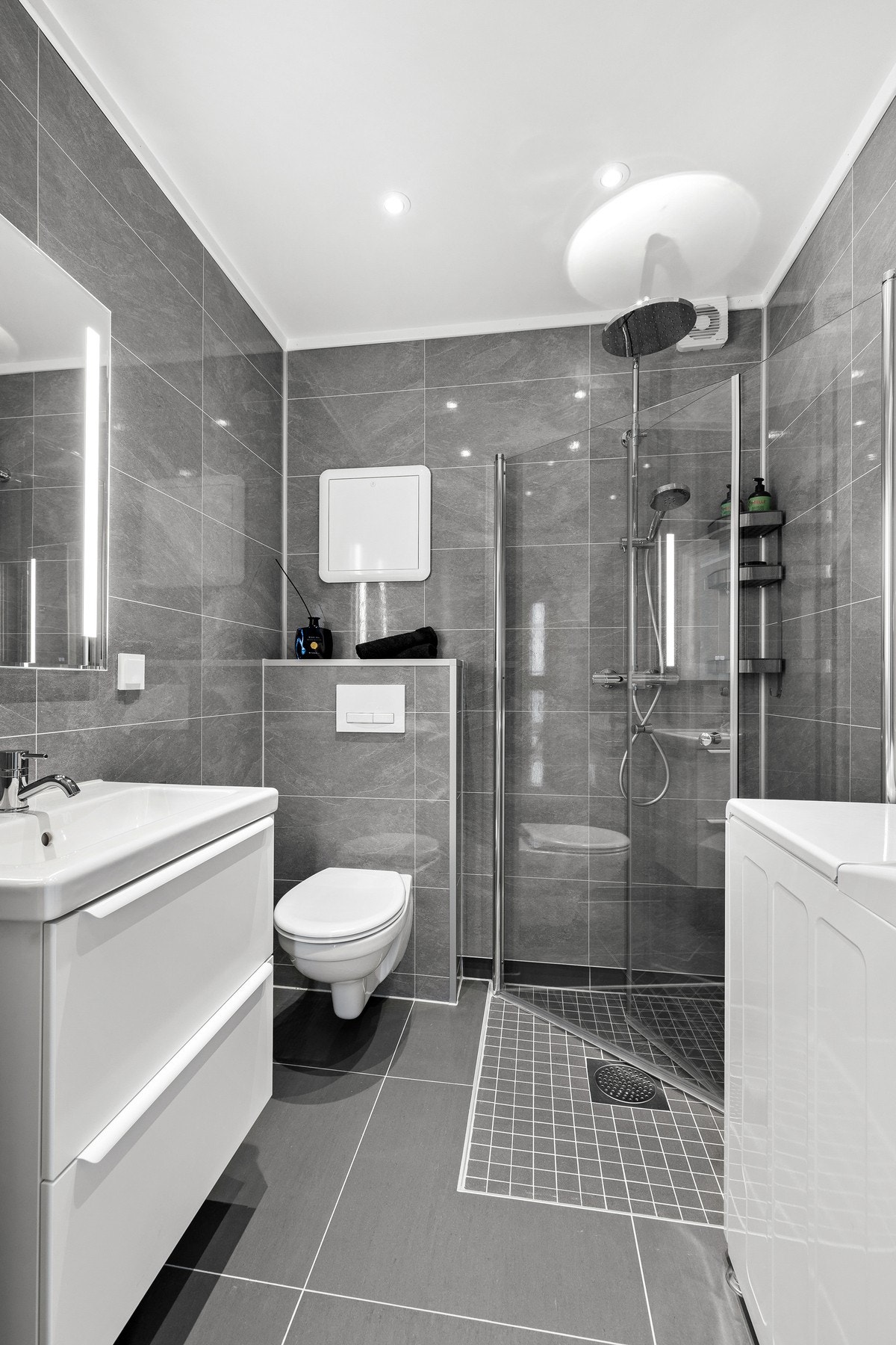 Pent bad fra 2024 utstyrt med vegghengt toalett og dusjhjørne med innfellbare glassdører Galleribilde