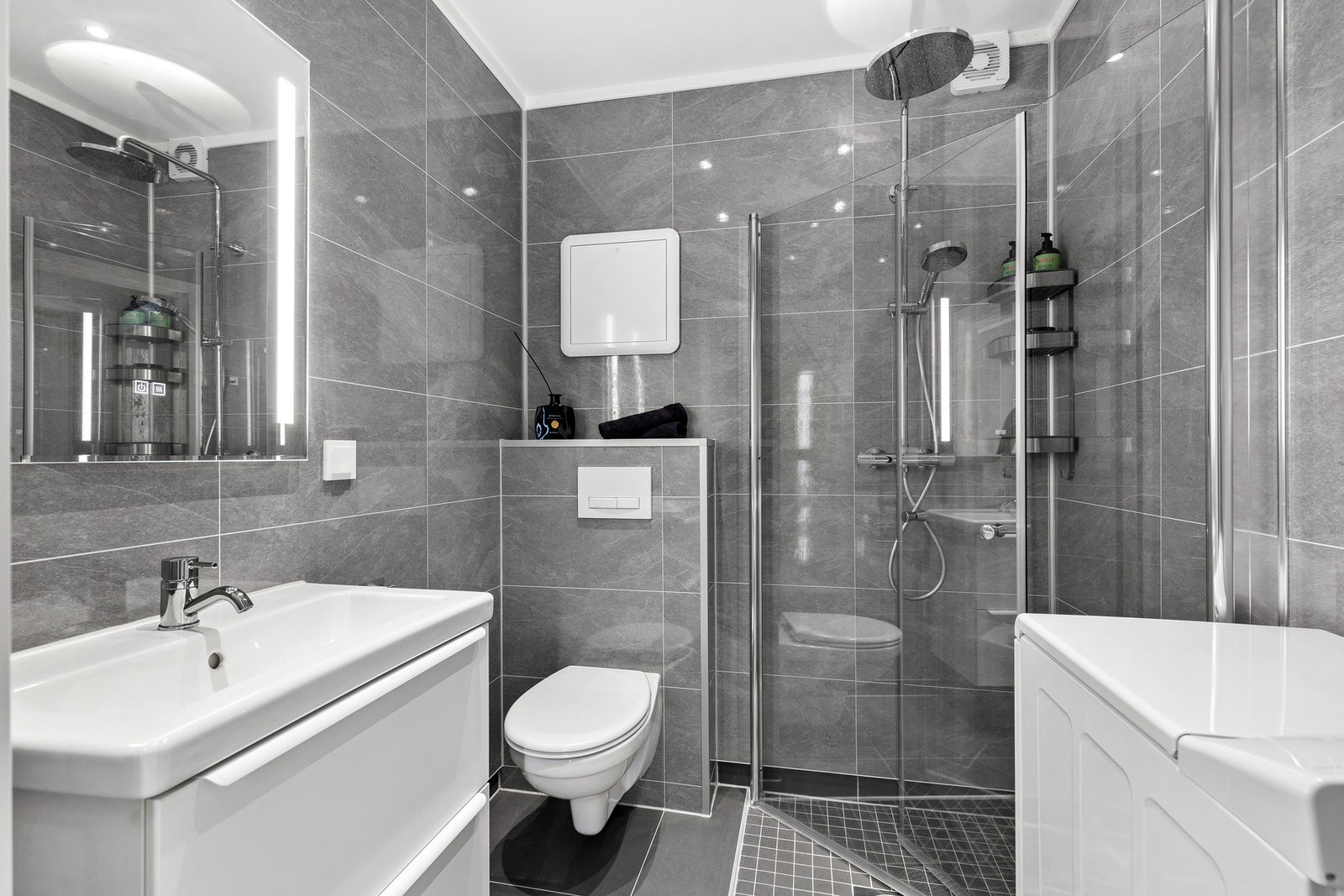 Toalettet er vegghengt med innebygd sisterne, og det er opplegg for vaskemaskin Galleribilde