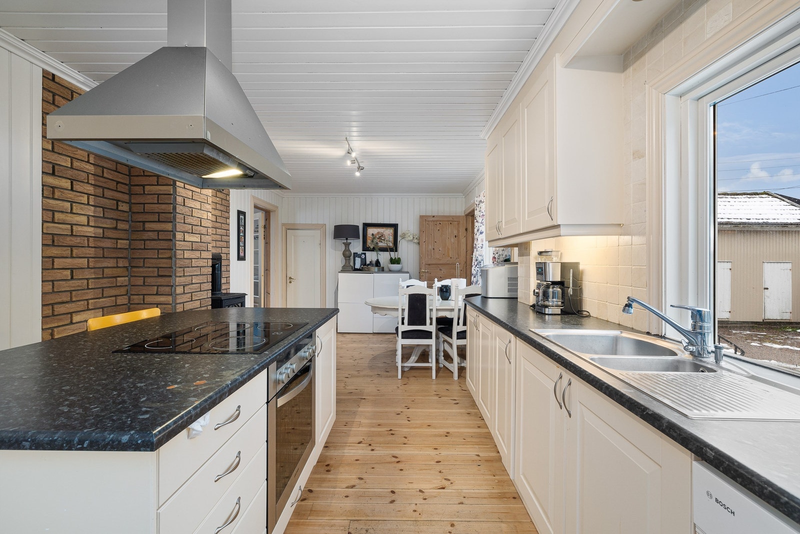 Stort kjøkken med plass til spisebord og kjøkkenøy Galleribilde