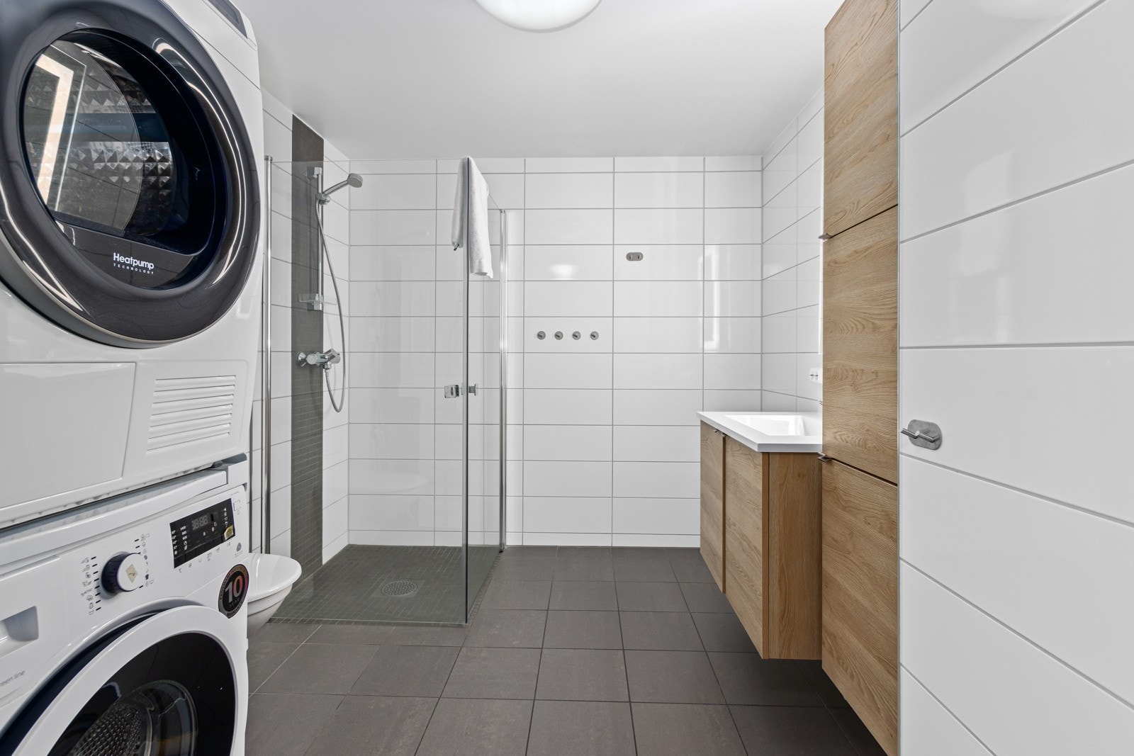 Av utstyr finnes opplegg for vaskemaskin, servant i skap med god lagringsplass, dusjvegger i glass og vegghengt toalett. Galleribilde