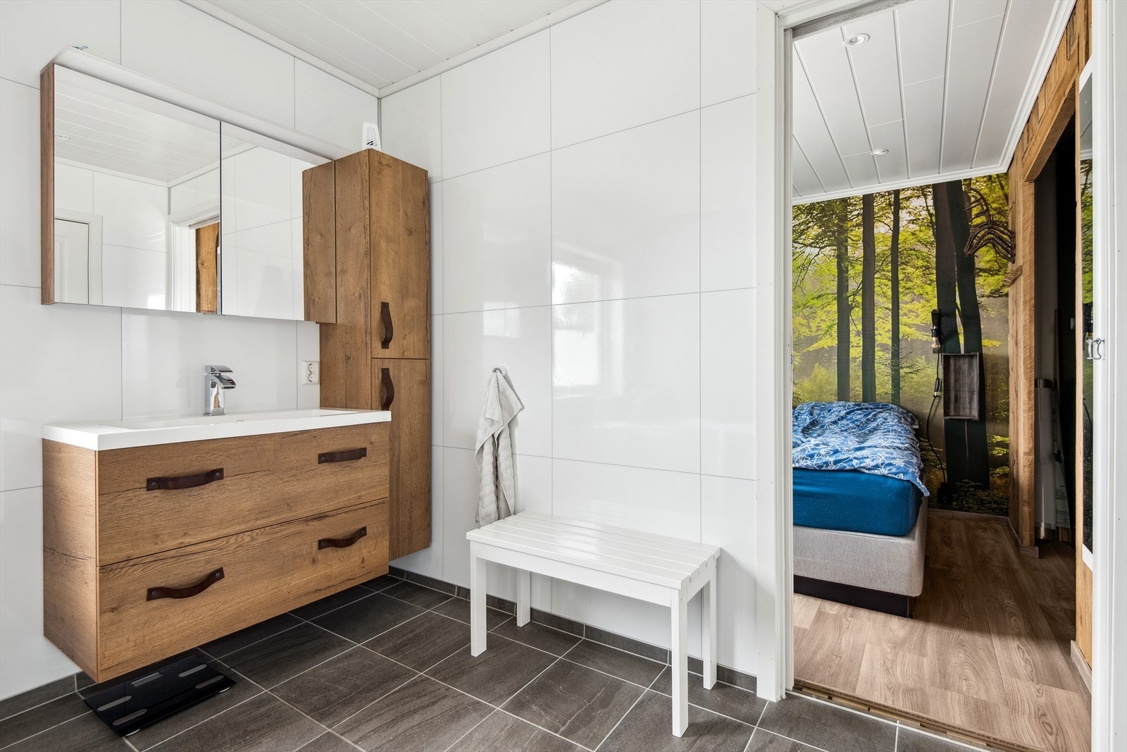 Badet i hovedetasjen er oppført med fliser på gulvet m/elektriske varmekabler. Veggene har baderomsplater. Mdf ferdigmalte panelbord i himling. Galleribilde