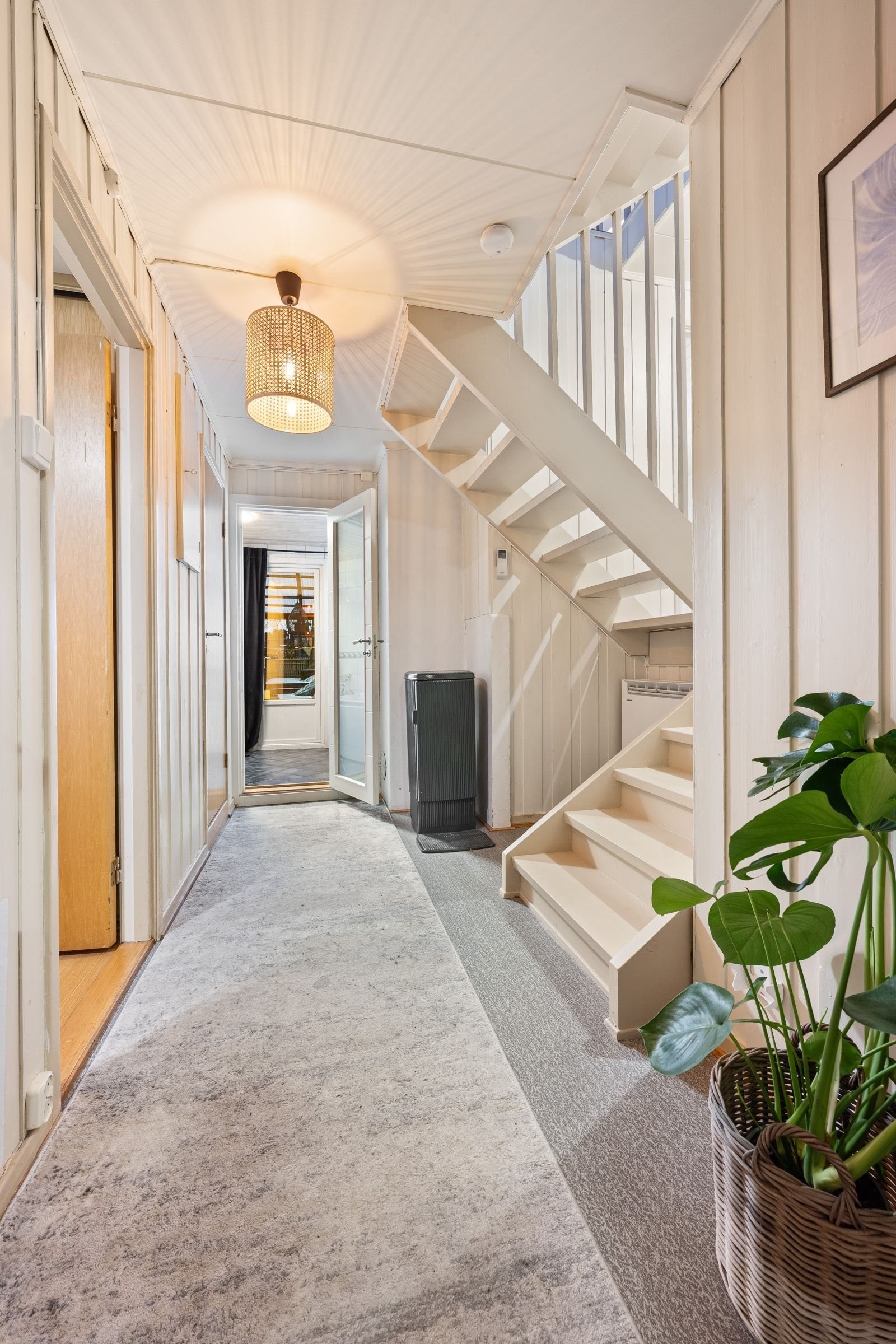 Boligen har flere halvetasjer. Fra gangen nede kan man gå gjennom badet og ut i hagen. Galleribilde