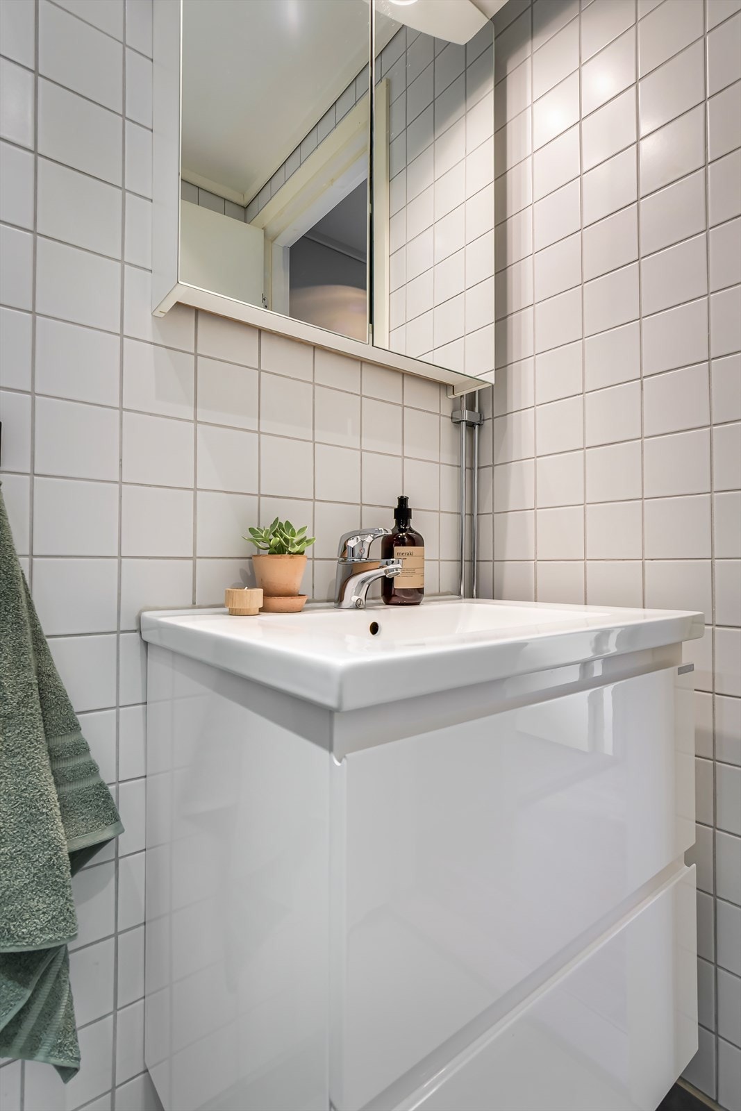 Badet er innredet med servant i skuffeseksjon og speilskap for oppbevaring. Galleribilde