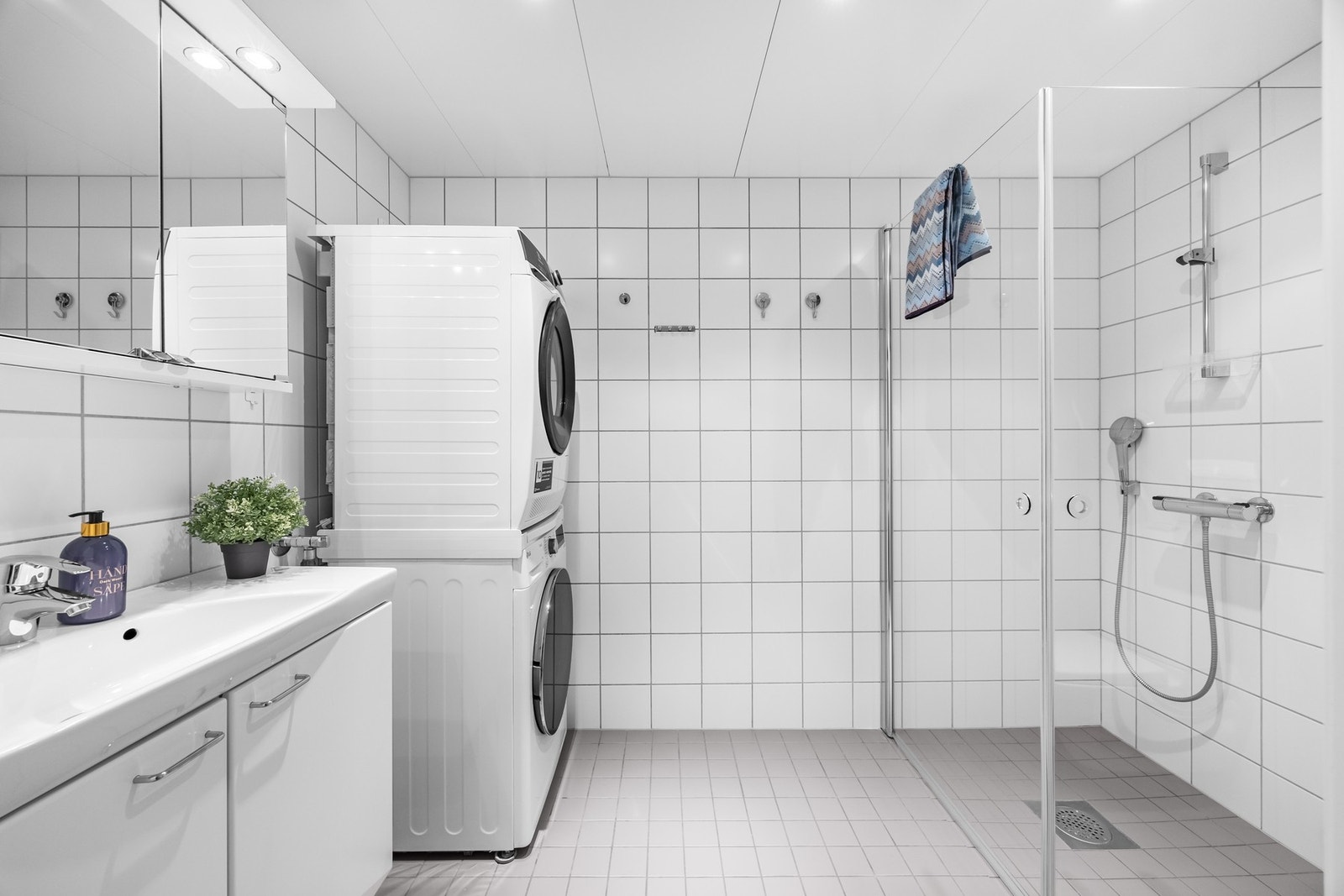 Leiligheten har et pent, flislagt bad med varme i gulv og downlights i himling. Heldekkende servant og speilskap med lys. Galleribilde