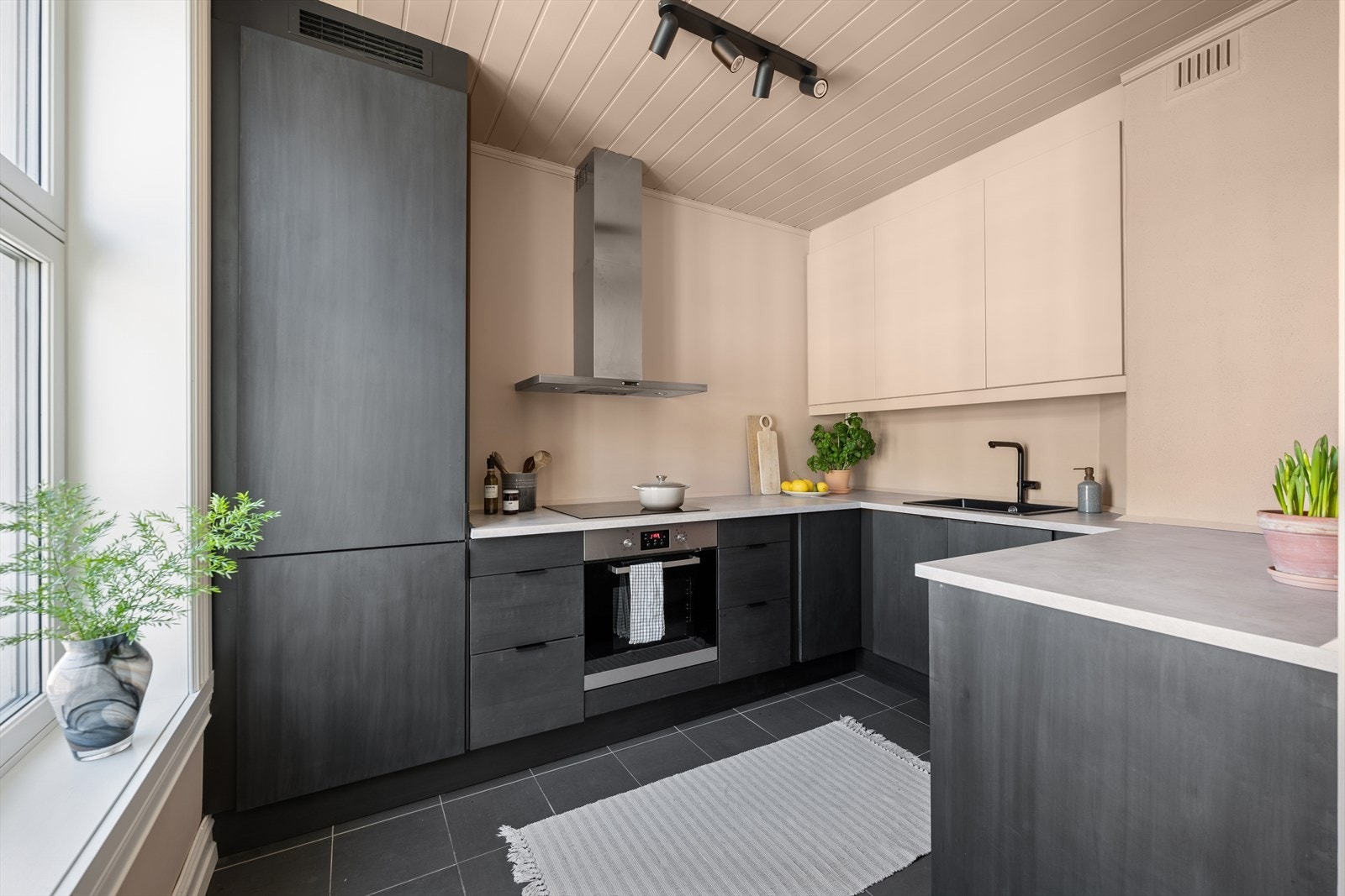 Lekkert kjøkken med fronter skåret ut av møbelsnekker- noe som gir kjøkkenet et unikt uttrykk Galleribilde