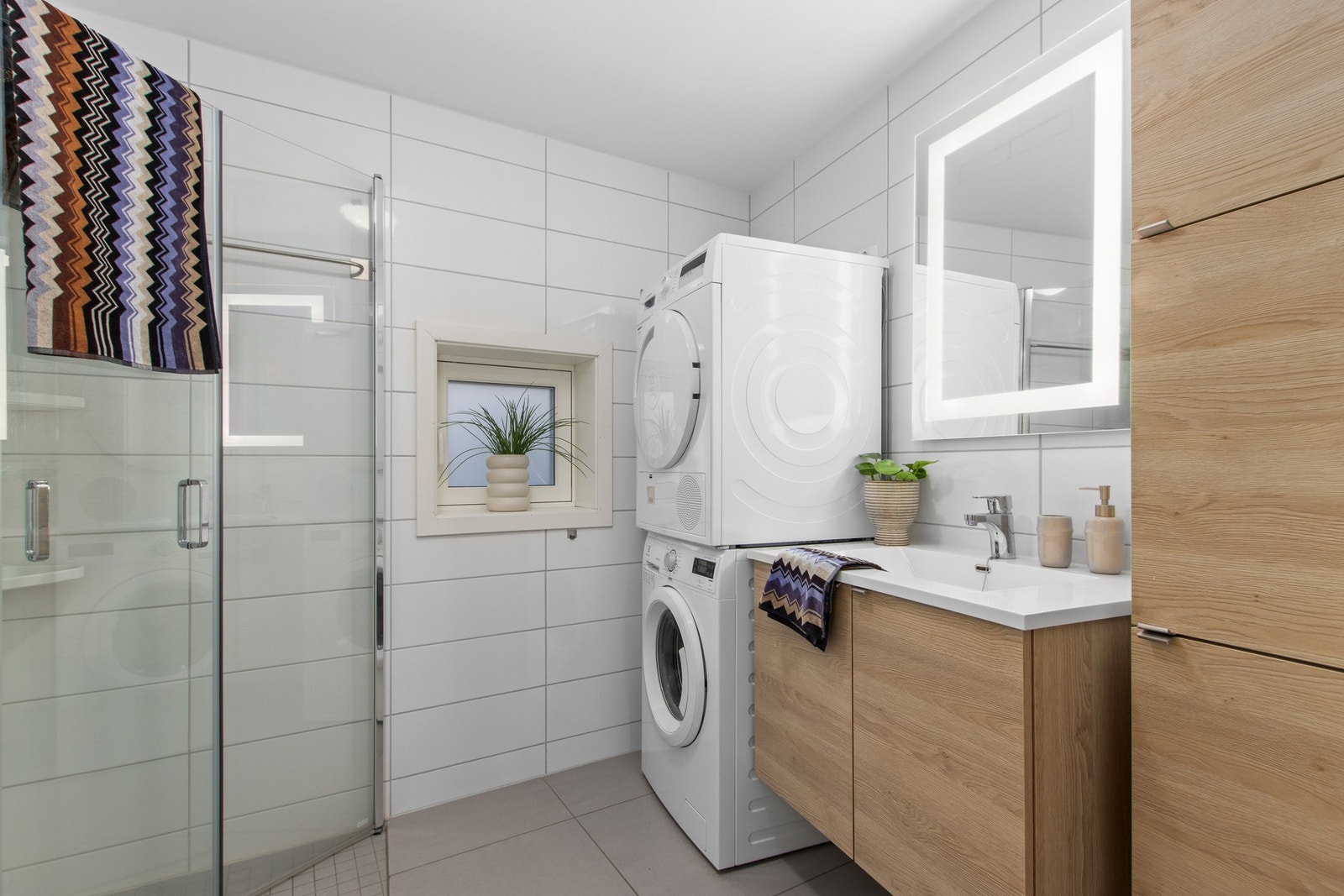 Pent bad som er flislagt og har varmekabler i gulv. Badet har godt med lagringsplass i servant- og høyskap. Galleribilde