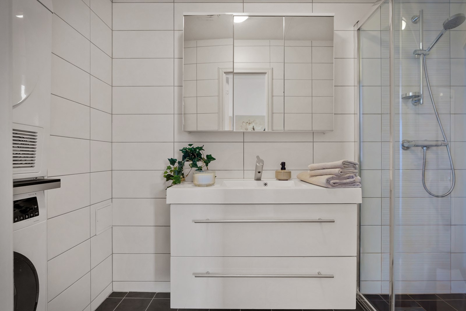 - Badet har behagelig gulvvarme og inneholder benkeskap med servant, speilskap, opplegg for vaskemaskin og dusjhjørne - Galleribilde