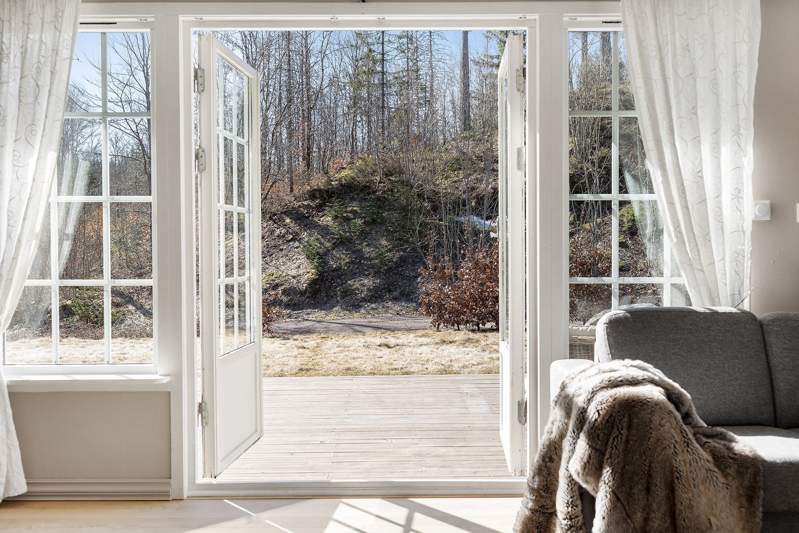 Stuen har store vindusflater med doble dører ut til terrassen og hagen. Her har man sol hele dagen sommerstid og man er skjermet for innsyn. Galleribilde