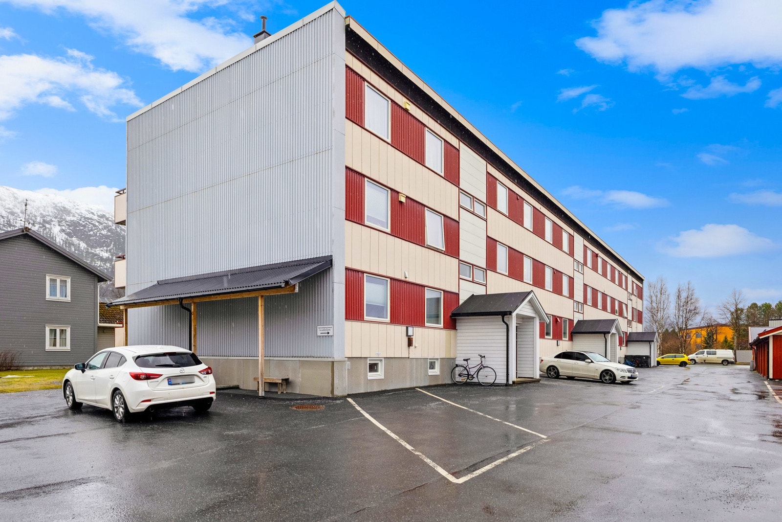 Byggets fasade, med parkeringsplass til høyre for inngangspartiet. Galleribilde