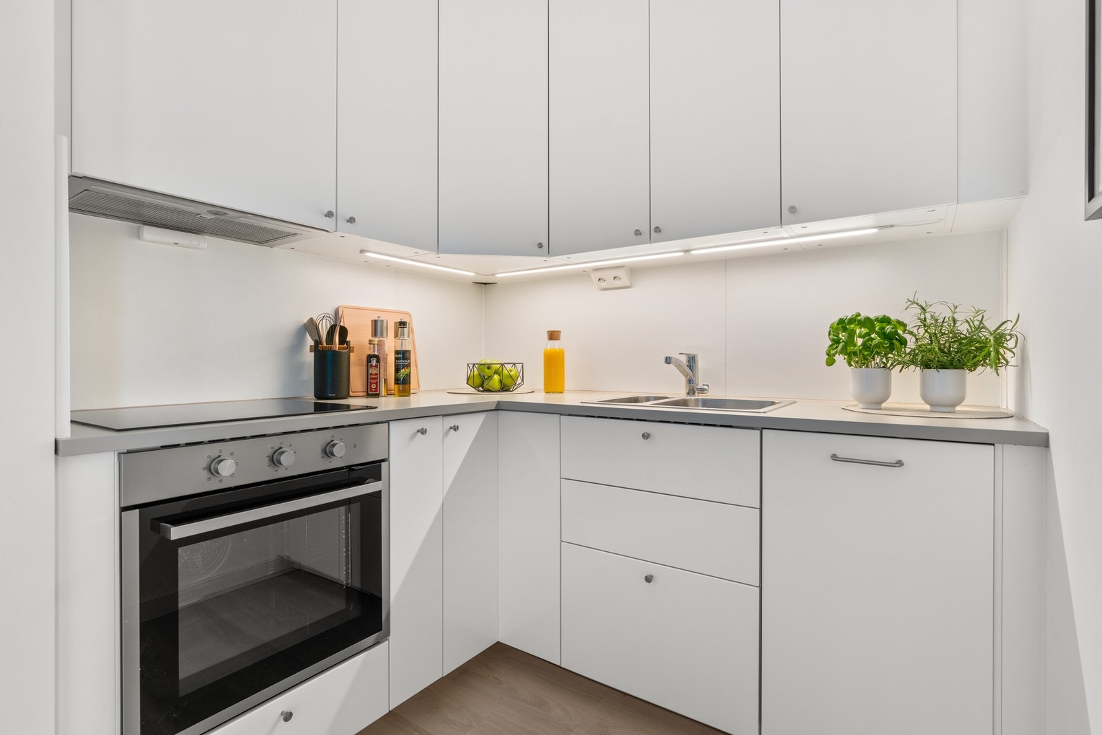 Videre er kjøkkenet utstyrt med integrerte hvitevarer som oppvaskmaskin, stekeovn og koketopp, samt kullfilterventilator og benkestikk. Galleribilde