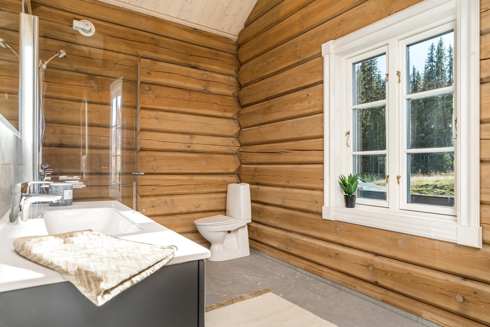 Delikat bad med fliser på gulv og tømmer på veggene som gir det gode hyttepreget. Galleribilde