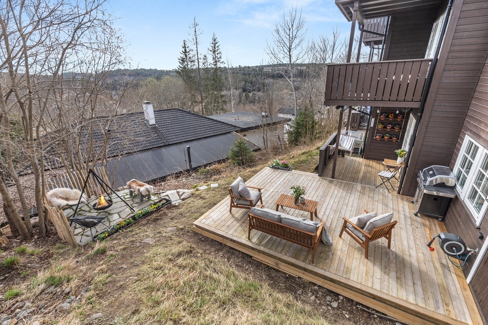 Stort uteområde som er delt opp i flere soner. Her finner du både plass til en solrik sittegruppe på terrassen, plass til stoler og benker rundt bålpannen og et lite kafé-sett med overbygg ved tarrassedøren. Galleribilde