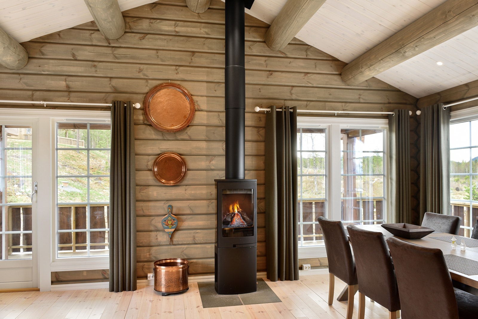 Stue, spisestue og kjøkken er på til sammen 34 kvm. Fra stua har du utgang til terrassen som ligger langs to vegger og skaper fine uteplasser.
Foto fra et prosjekt der modellen er bygget med tilpasninger etter kundeønske, bla. er hytta speilvendt. Galleribilde