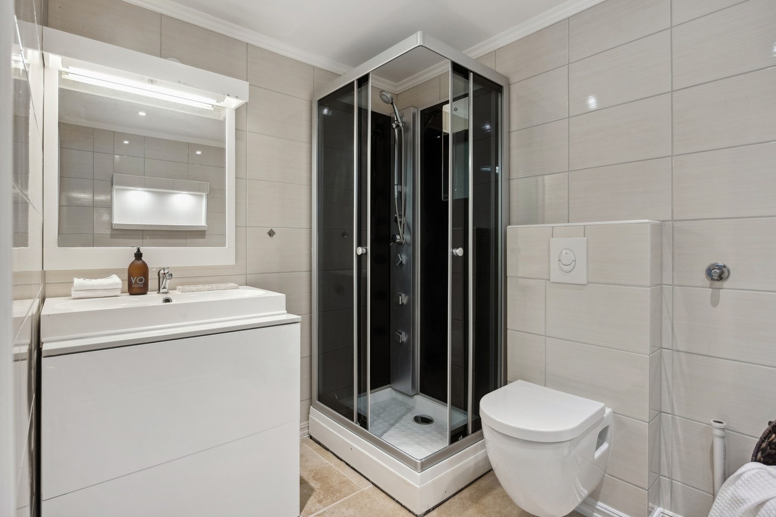 Badet har vegghengt toalett og dusjkabinett. Det er montert varme i gulvet. Galleribilde