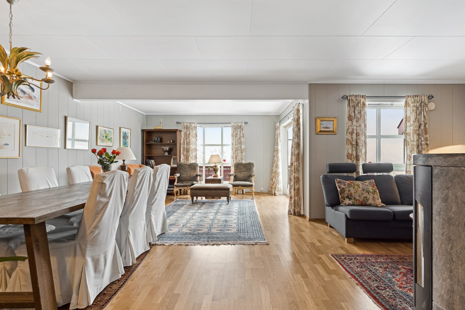Stor stue i vinkel, med gode møbleringsmuligheter. Godt med plass for et stort spisebord og flere sittegrupper. Lunt hjørne for salongen, med nærhet til en vedovn for varme og ekstra hygge. Galleribilde