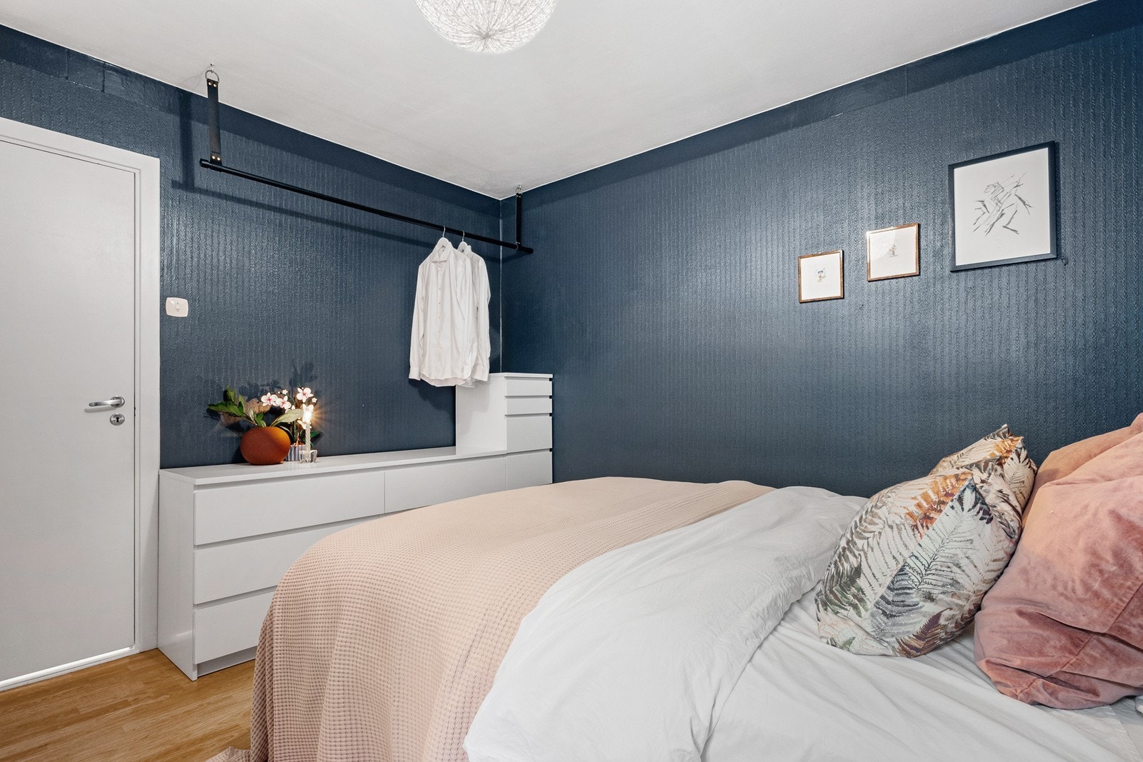 Boligen har to soverom, begge med et stort vindu, parkett på gulv og lune farger. Galleribilde