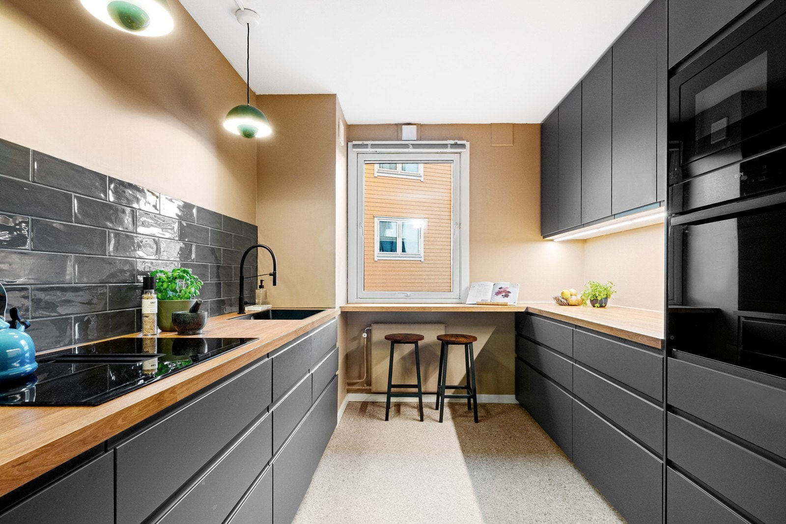 Under vinduet i enden av rommet er en benkeplate med plass til barstoler - et hyggelig frokost- eller kaffehjørne. Galleribilde