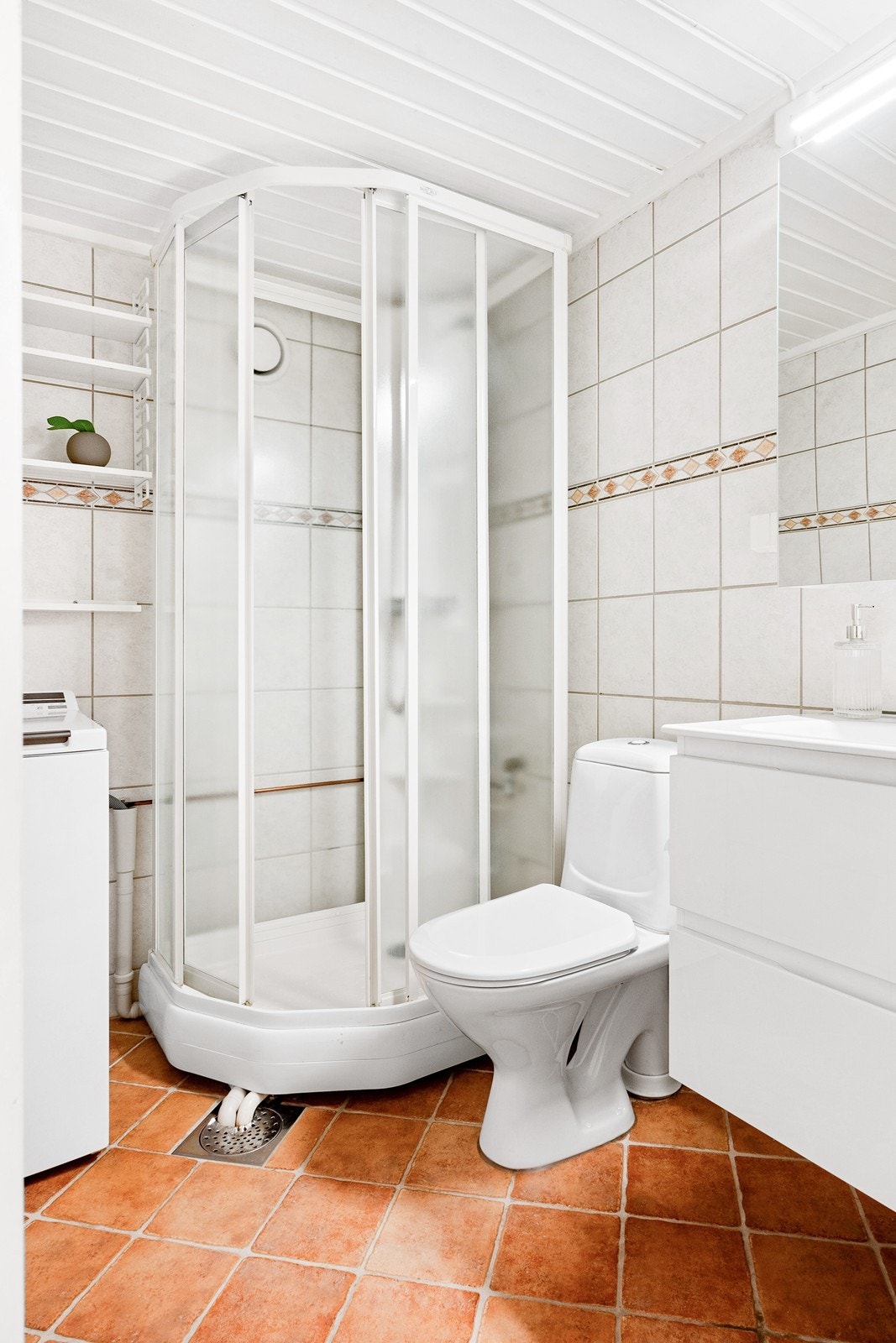 Badet har flislagte overflater, gulvvarme, opplegg for vaskemaskin og delvis innredning fra 2023. Galleribilde