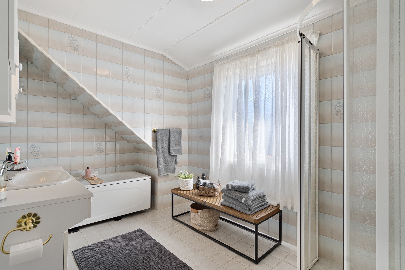 Etasjen har også et lekkert, flislagt bad med nedfelt servant i innredning, toalett, badekar og dusj med glassvegger Galleribilde