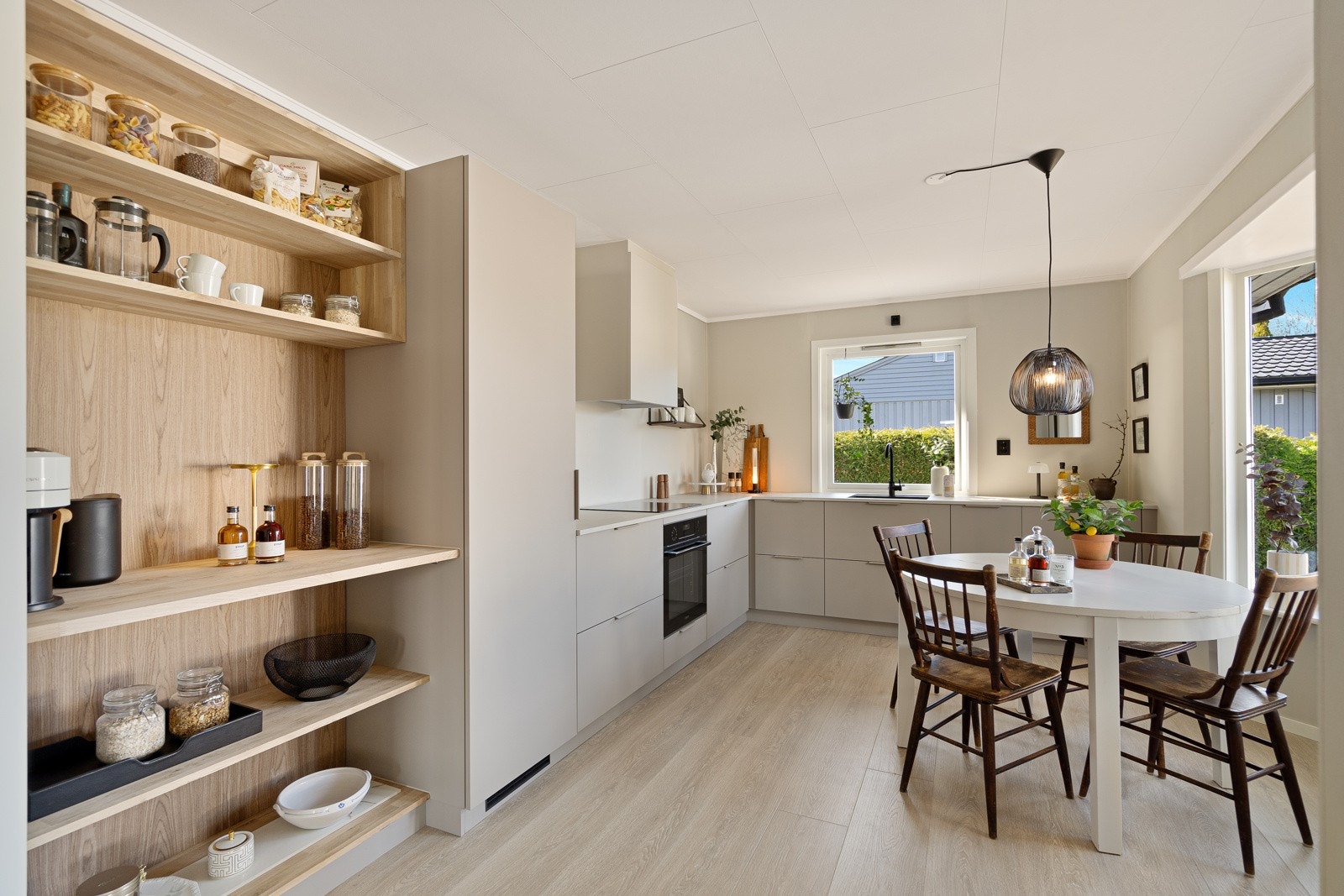 Kjøkkenet fremstår lyst og stilrent, med godt med skap- og benkeplass Galleribilde