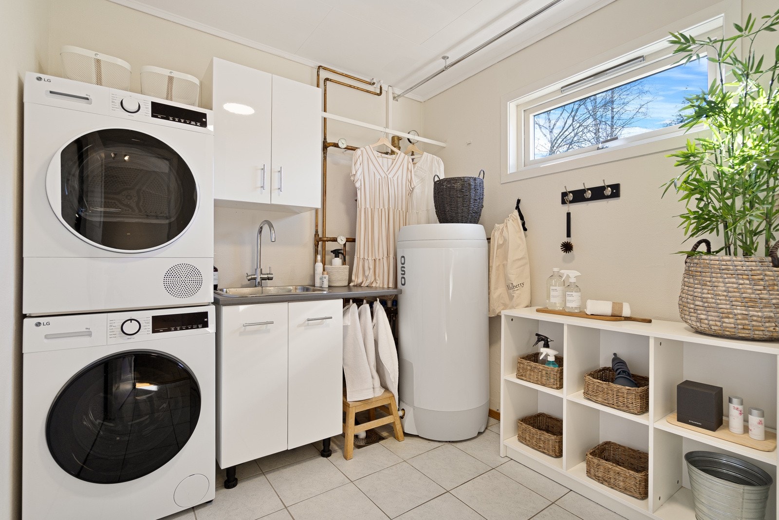 Praktisk vaskerom. Rommet er utstyrt med opplegg for både vaskemaskin og tørketrommel, samt en utslagsvask. Her står også en nyere varmtvannsbereder på 200 liter og det tekniske anlegget for den vannbårne gulvvarmen. Galleribilde