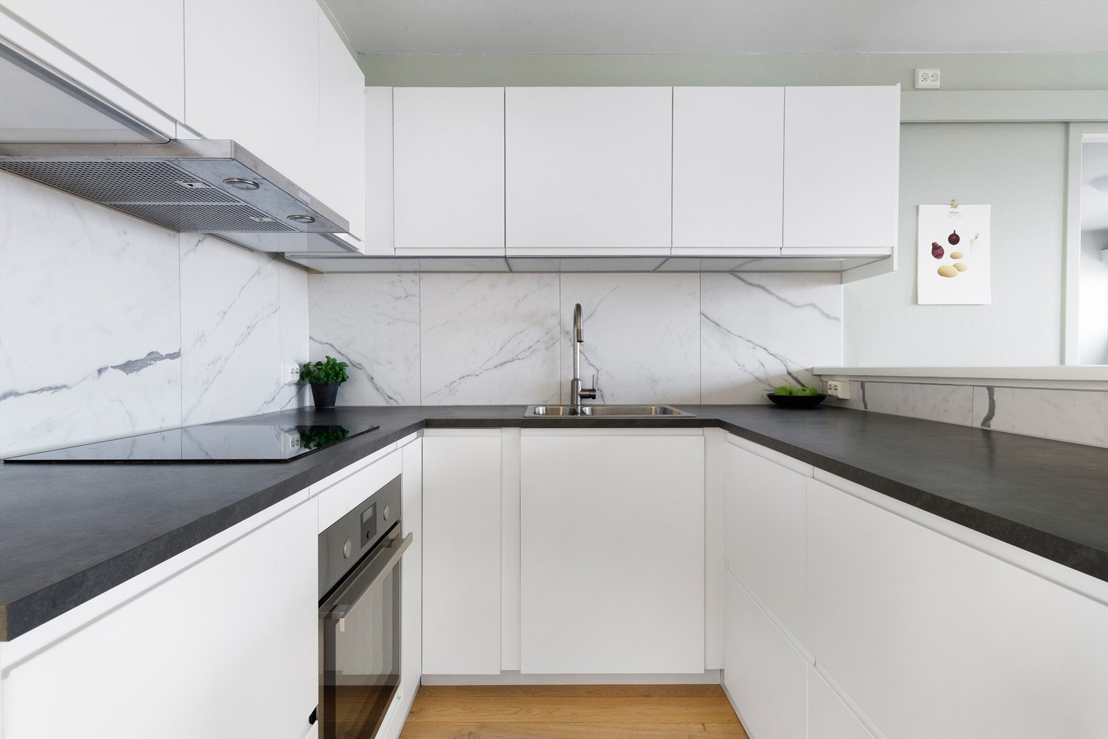 Flott kjøkken med overskap med hvite fronter og benkeplate av laminat Galleribilde