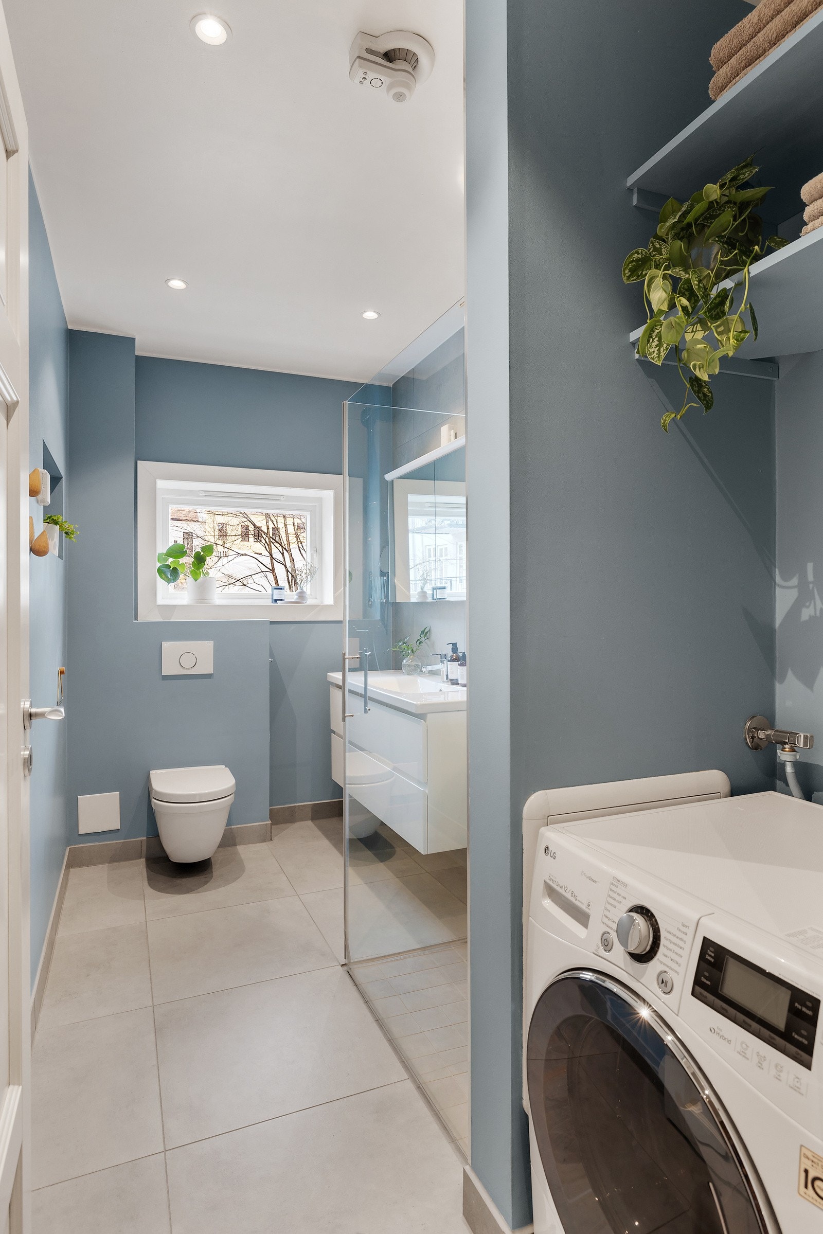 Det er plass og opplegg for vaskemaskin i nisje med hyller over. Galleribilde