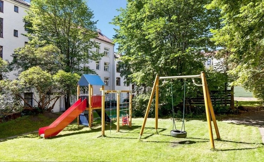 Bakgården er opparbeidet med store grønne plenarealer, diverse beplantning, asfalterte områder og lekeplass. Galleribilde