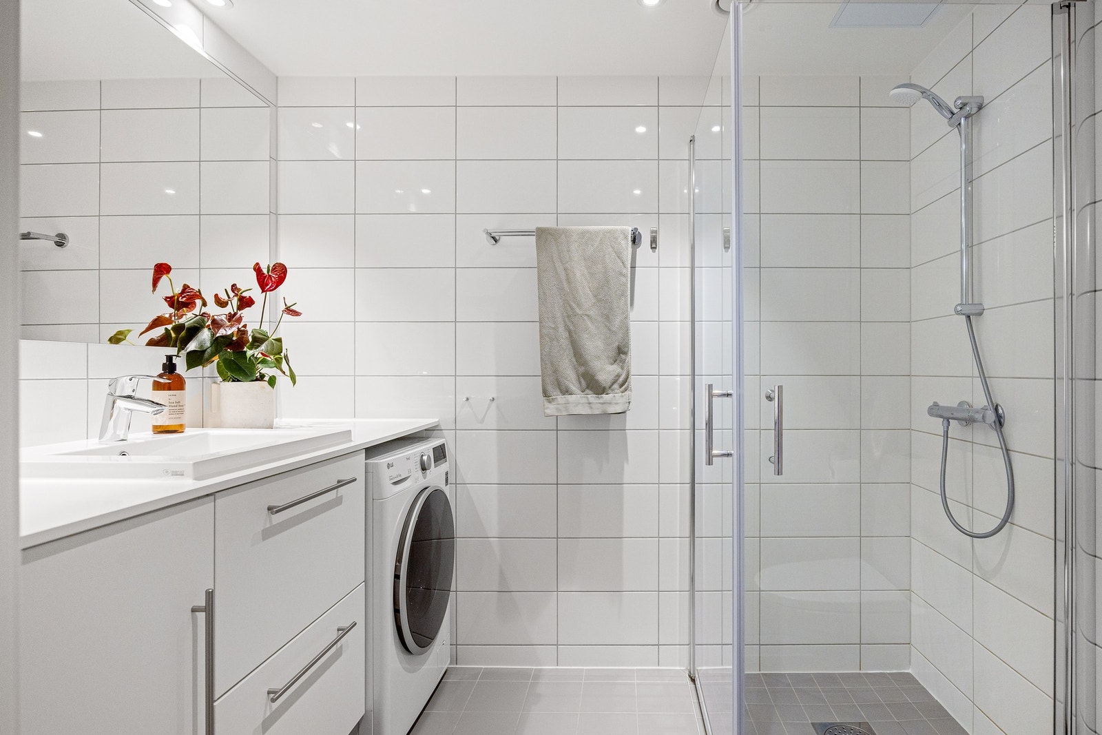 Lyst og lekkert bad med flislagte overflater og gulvvarme. Galleribilde