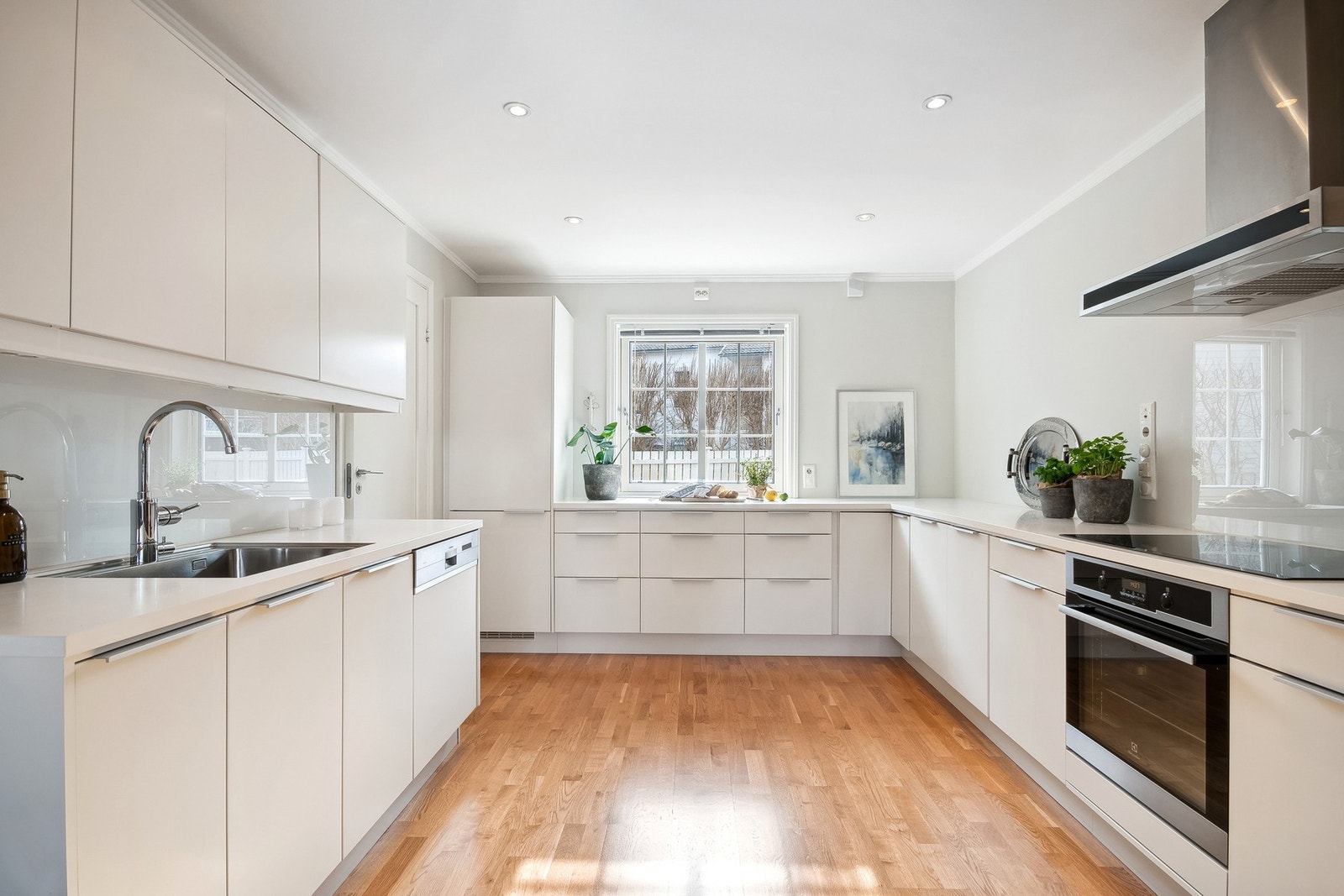 Stilrent og praktisk kjøkken med glatte fronter, laminat benkeplate og integrerte hvitevarer. Galleribilde