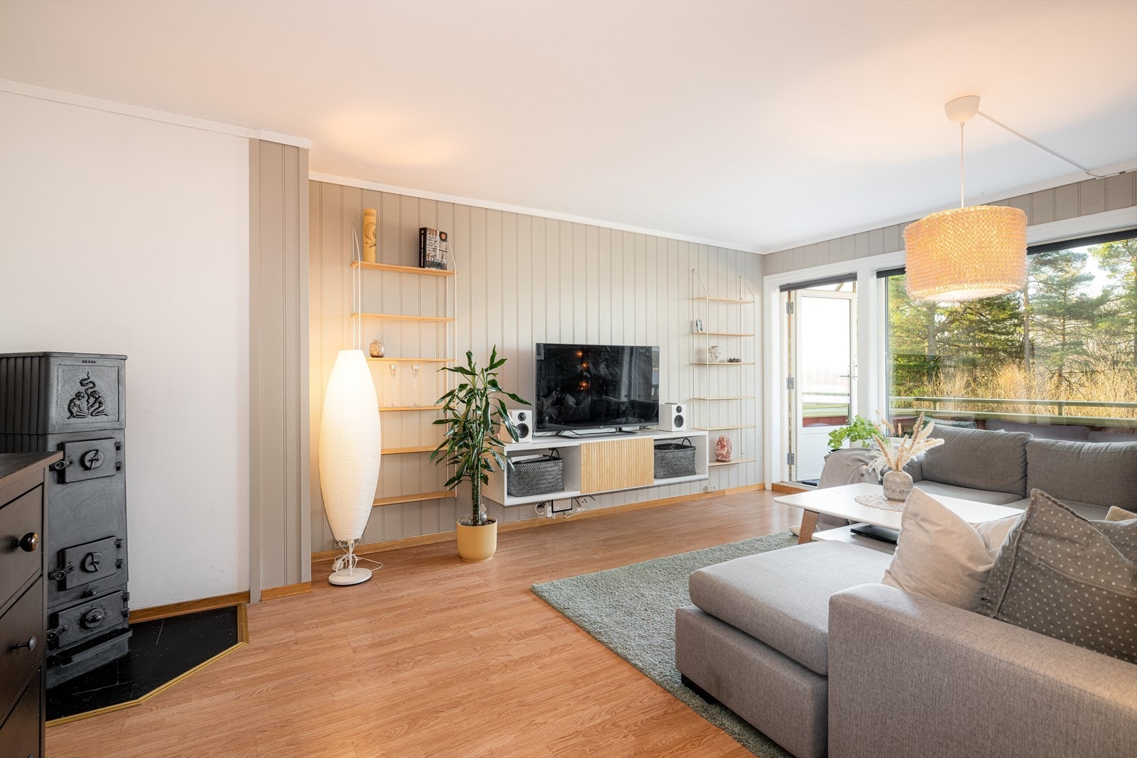 Lys og fin stue med plass til både sofa og annen møblering. Stue har laminat på gulv, og malte mdf-plater på vegg og malt mdf-panel i tak. Galleribilde