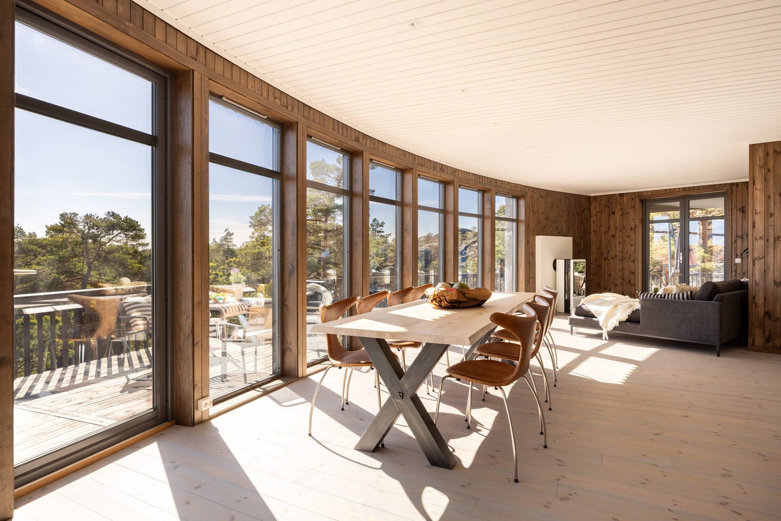 Hele hytta er åpnet opp mot fronten hvor den organiske formen danner naturlige oppholds soner. Ekstra høye vindusflater fra gulv til tak gir deg følelsen av å være i ett med landskapet utenfor. Galleribilde