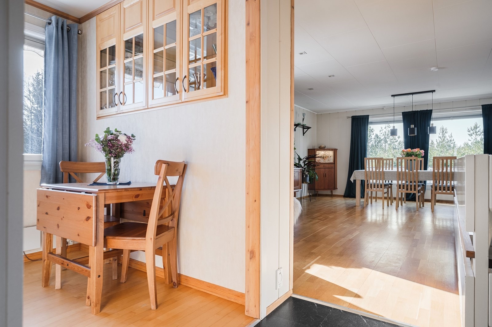 Det er delvis åpen løsning mot stue, og på veggen er det kjøkkenskap med glassfronter både mot kjøkken og stue. Galleribilde