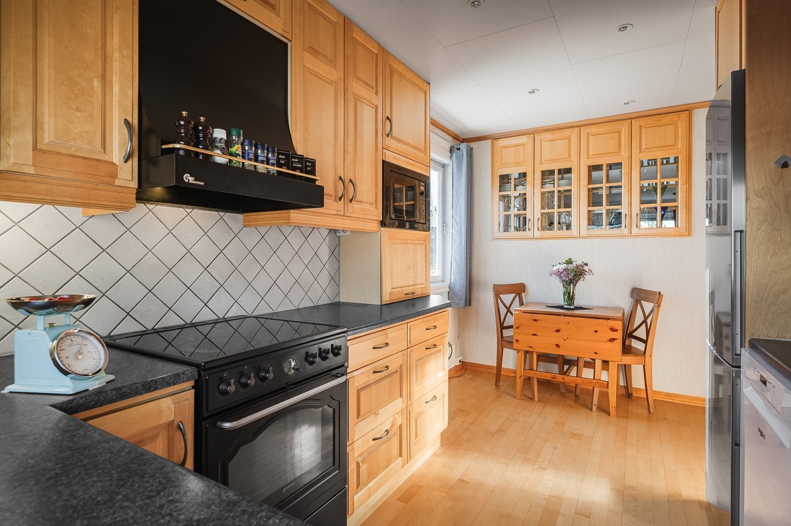 Innredningen har speil fronter på over- og underskap, laminert benkeplate og fliser i benkerygg. Galleribilde