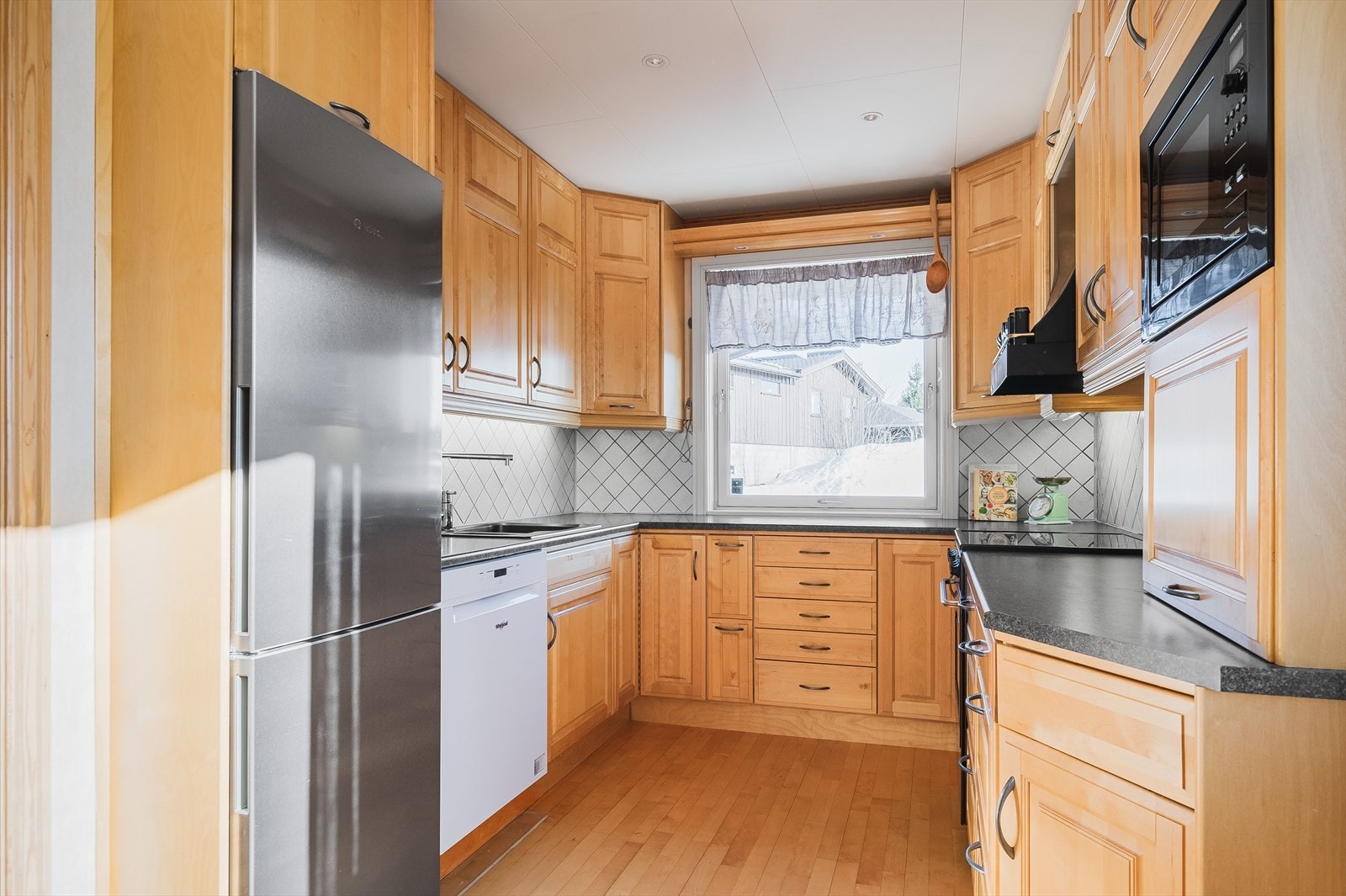 Kjøkkenet har en hyggelig fremtoning med god oppbevaringsplass i takhøye skap. Galleribilde