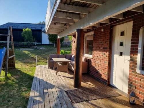 Eget inngangsparti til sokkeletasjen, tilknyttet terrasseplatting med plass for utemøblement. Galleribilde