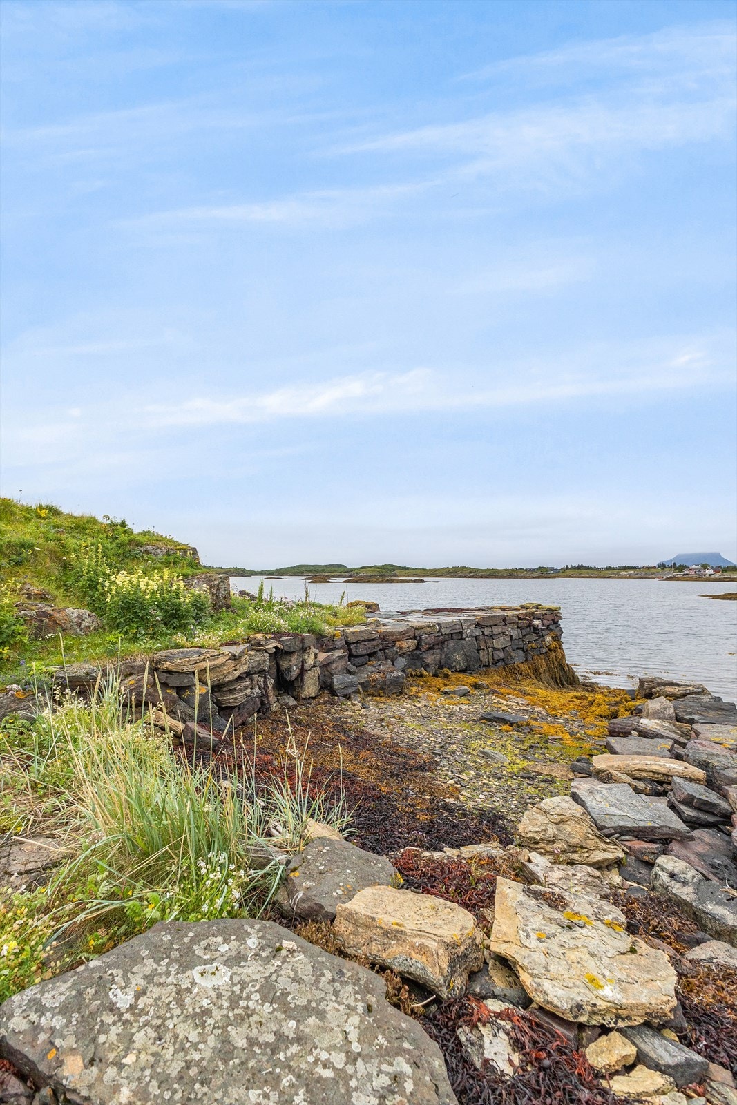Steinen som er brukt til å lage molo/brygge er fraktet hit med båt, og er en steinsort som ikke finnes naturlig på Sleneset. Galleribilde