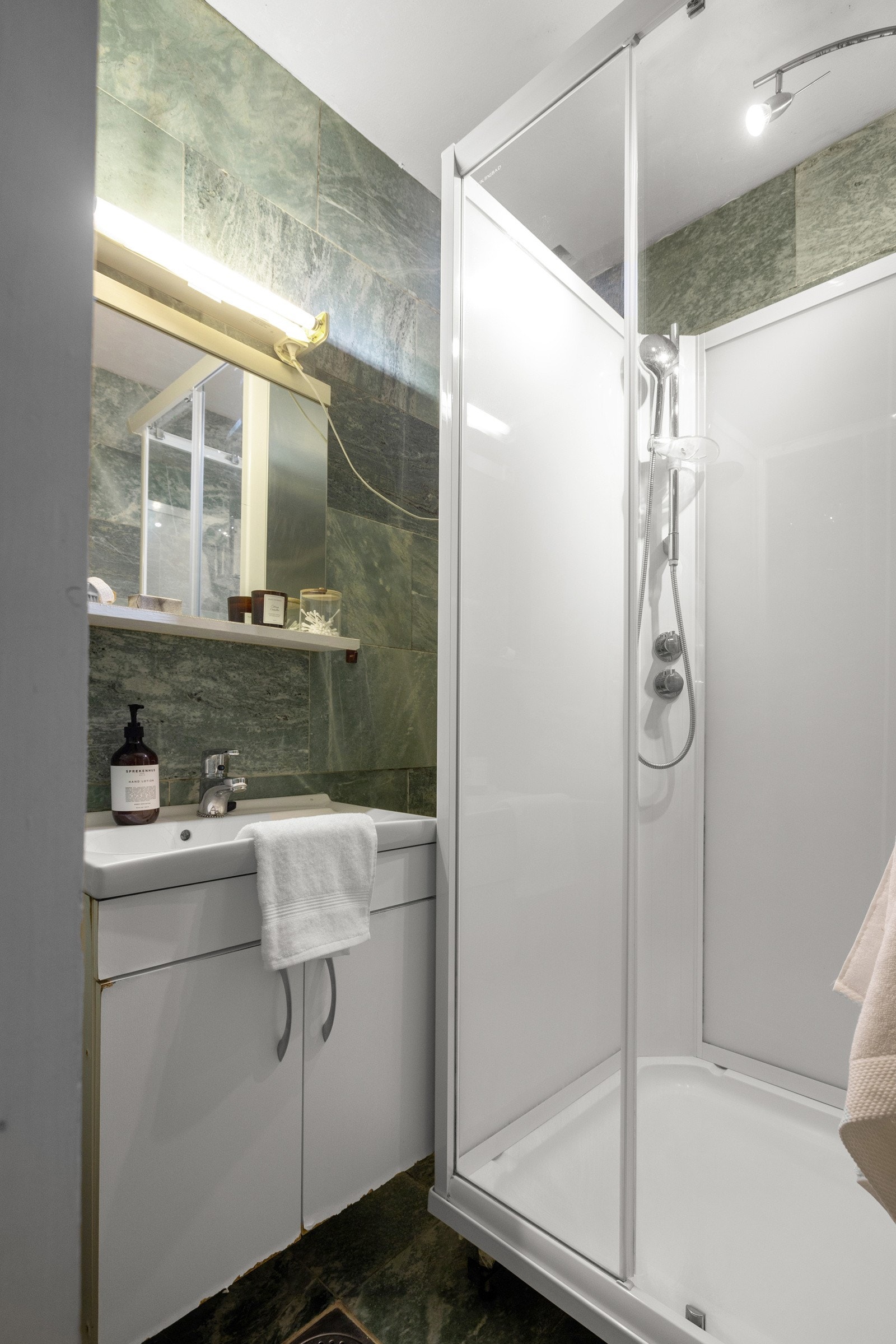 Badet er innredet med servant, underskap, speil og dusjkabinett. Galleribilde